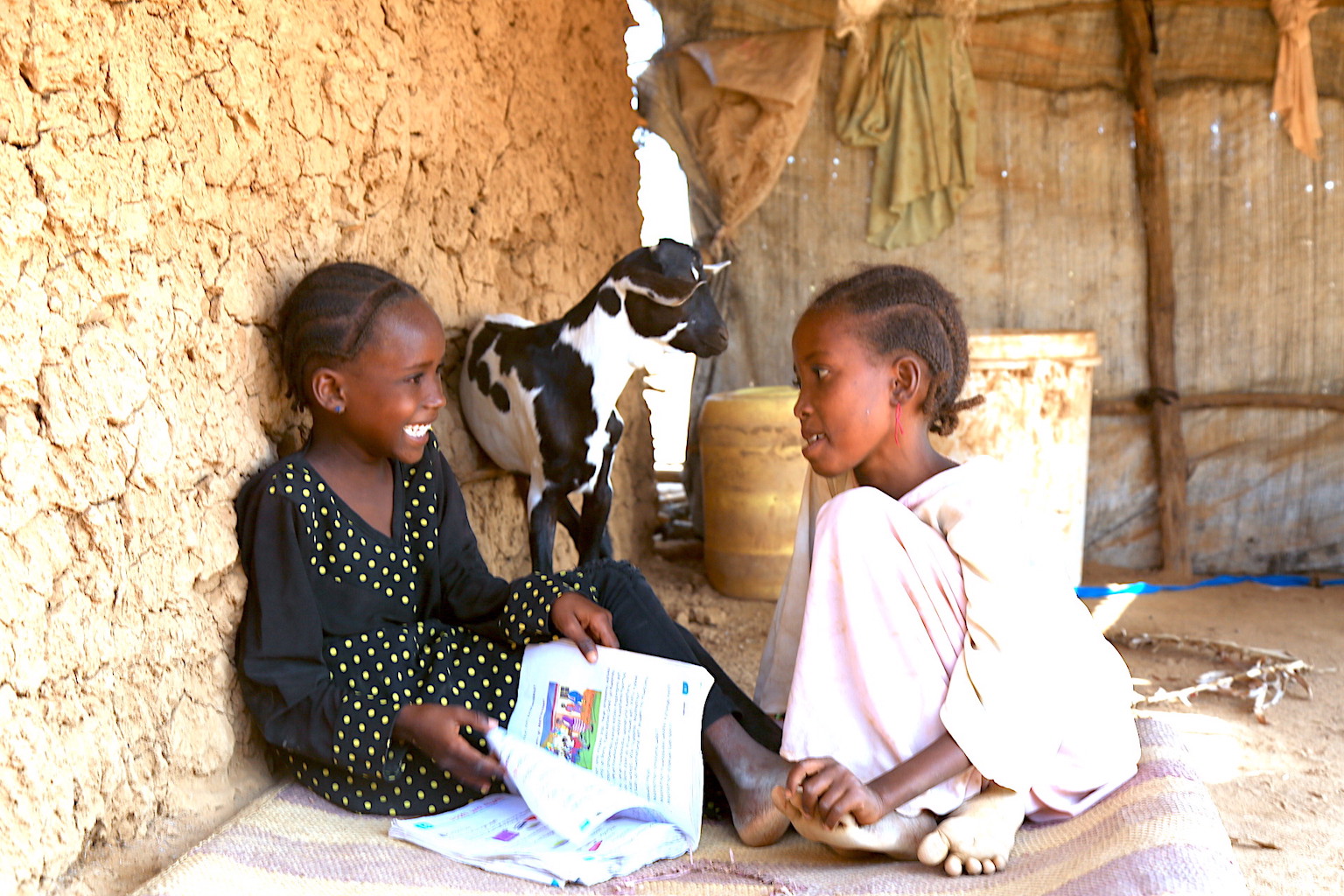 Children read a story outside their parents Salon