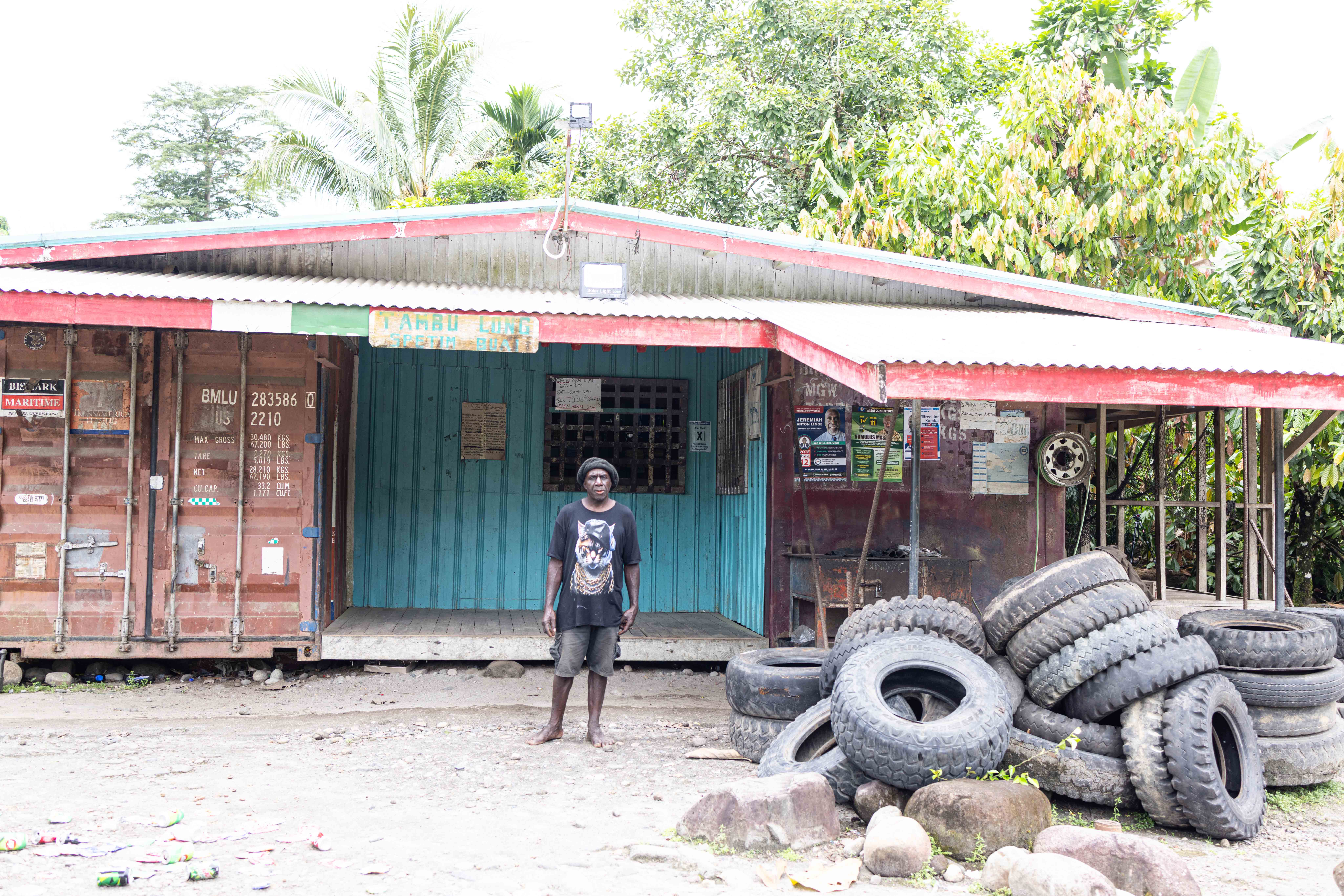 Sam proudly standing in front of his store, service station and tyre station.