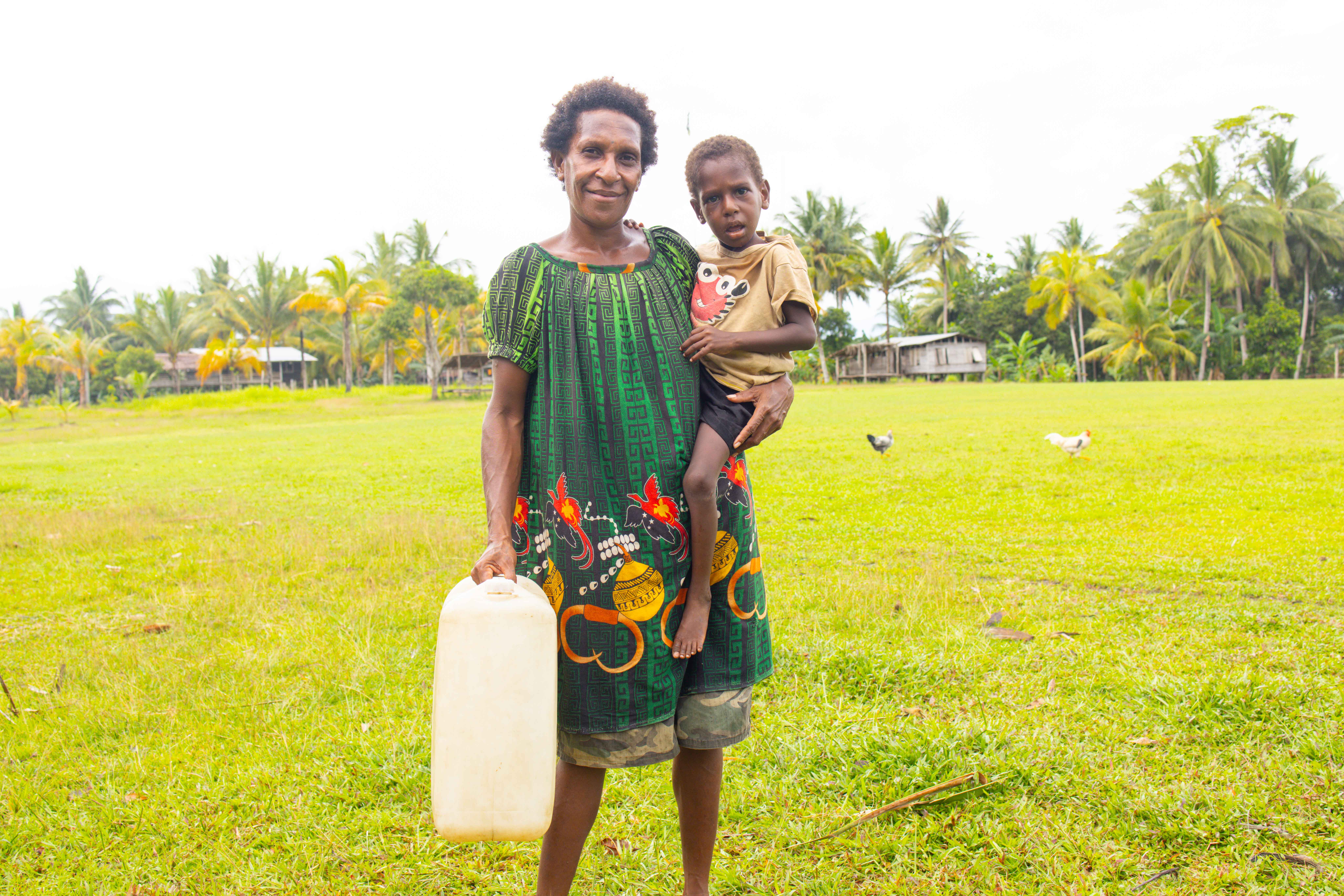 Siwakato Kena and her child with special needs displaying the jerry can donated by World Vision.