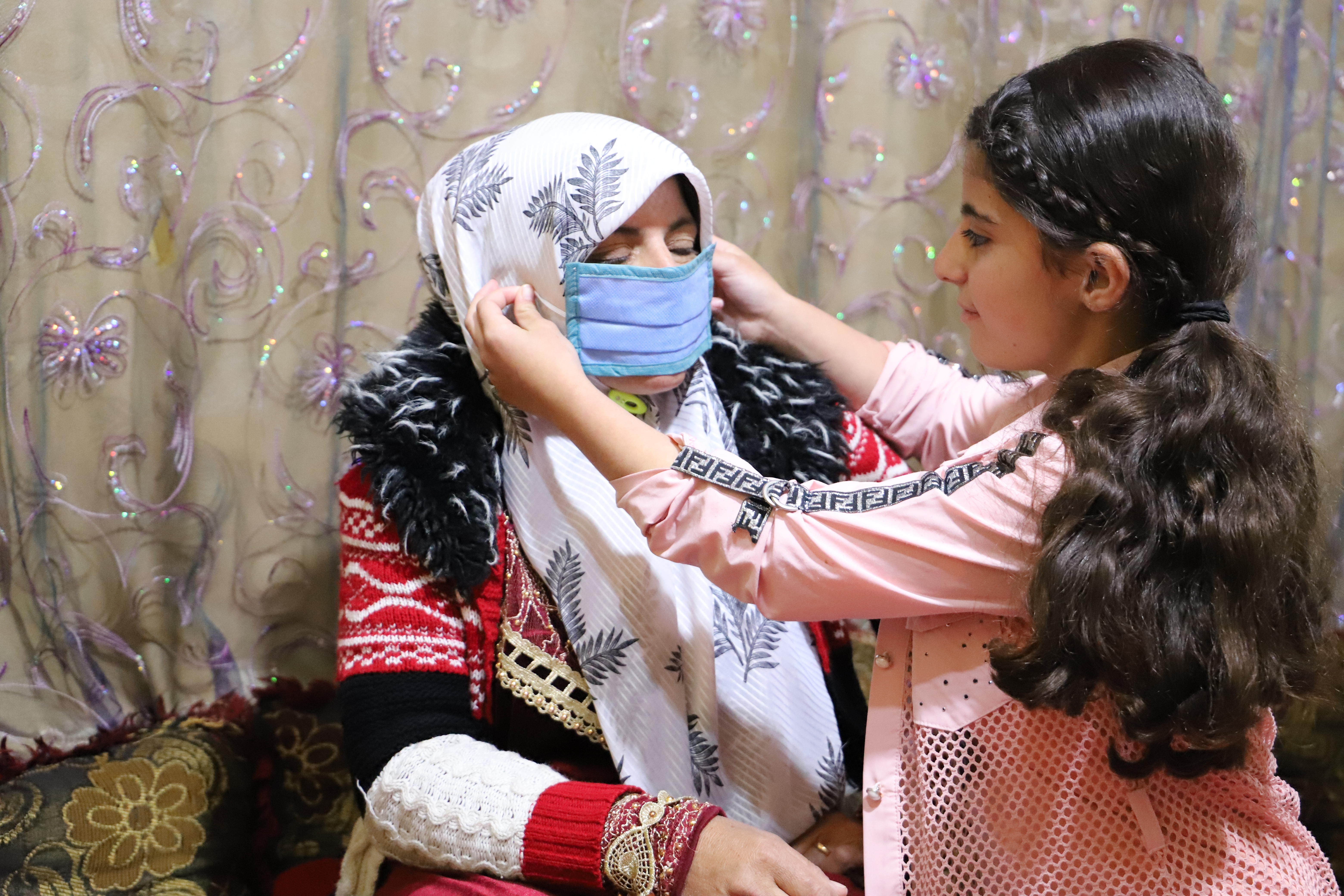 Yasmine showing her mom how to wear a mask