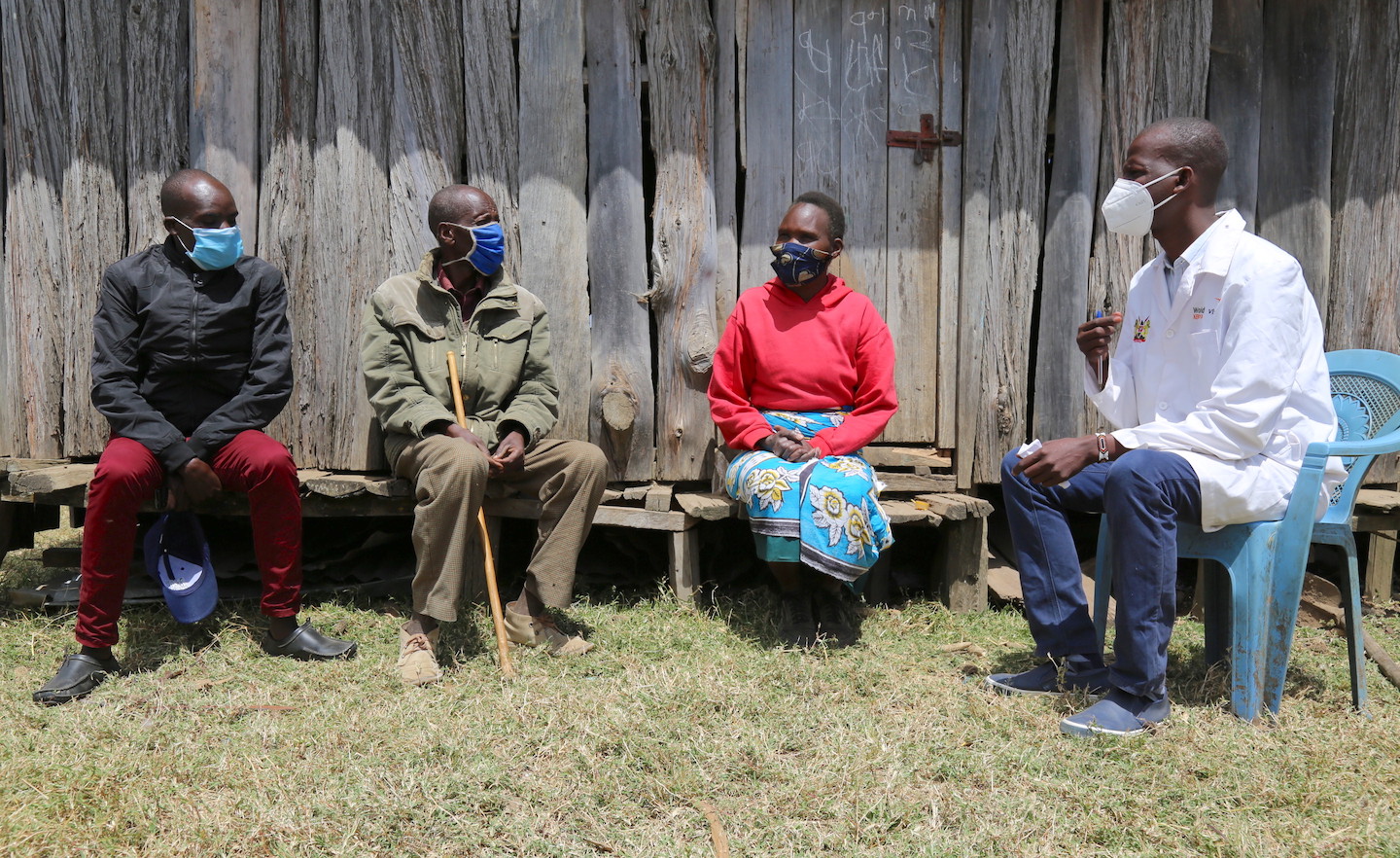 Saitoti, the community health volunteer speaking to Leyem and and his parents at their home 