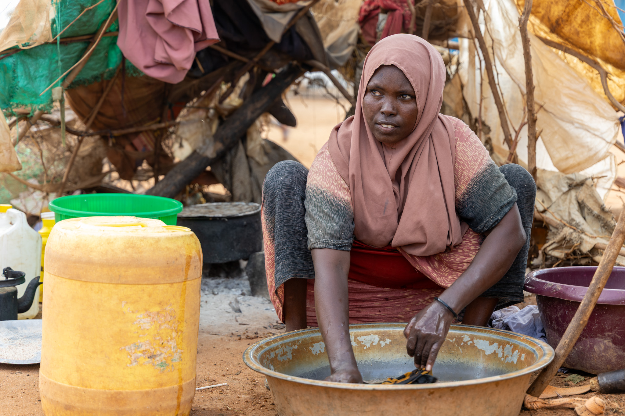 Hawa, Muslimo’s mother determination in her hands, washing clothes under the open sky