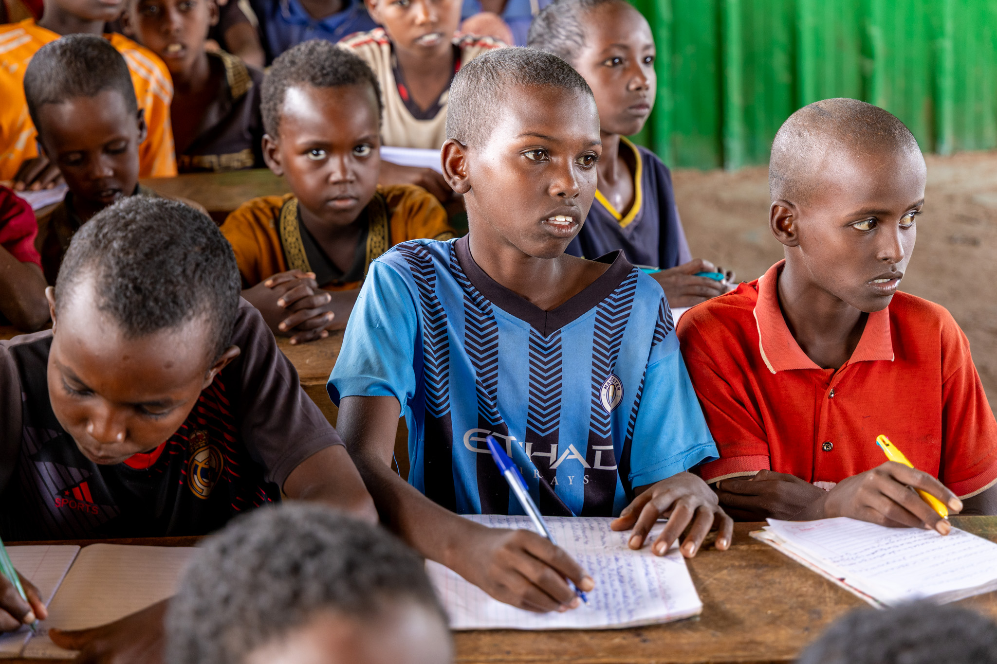 Shuaib, Muslimo’s younger brother, listens intently in class. Though still young, he carries a quiet awareness of his family’s struggles — education is his hope, and he holds onto it with care.