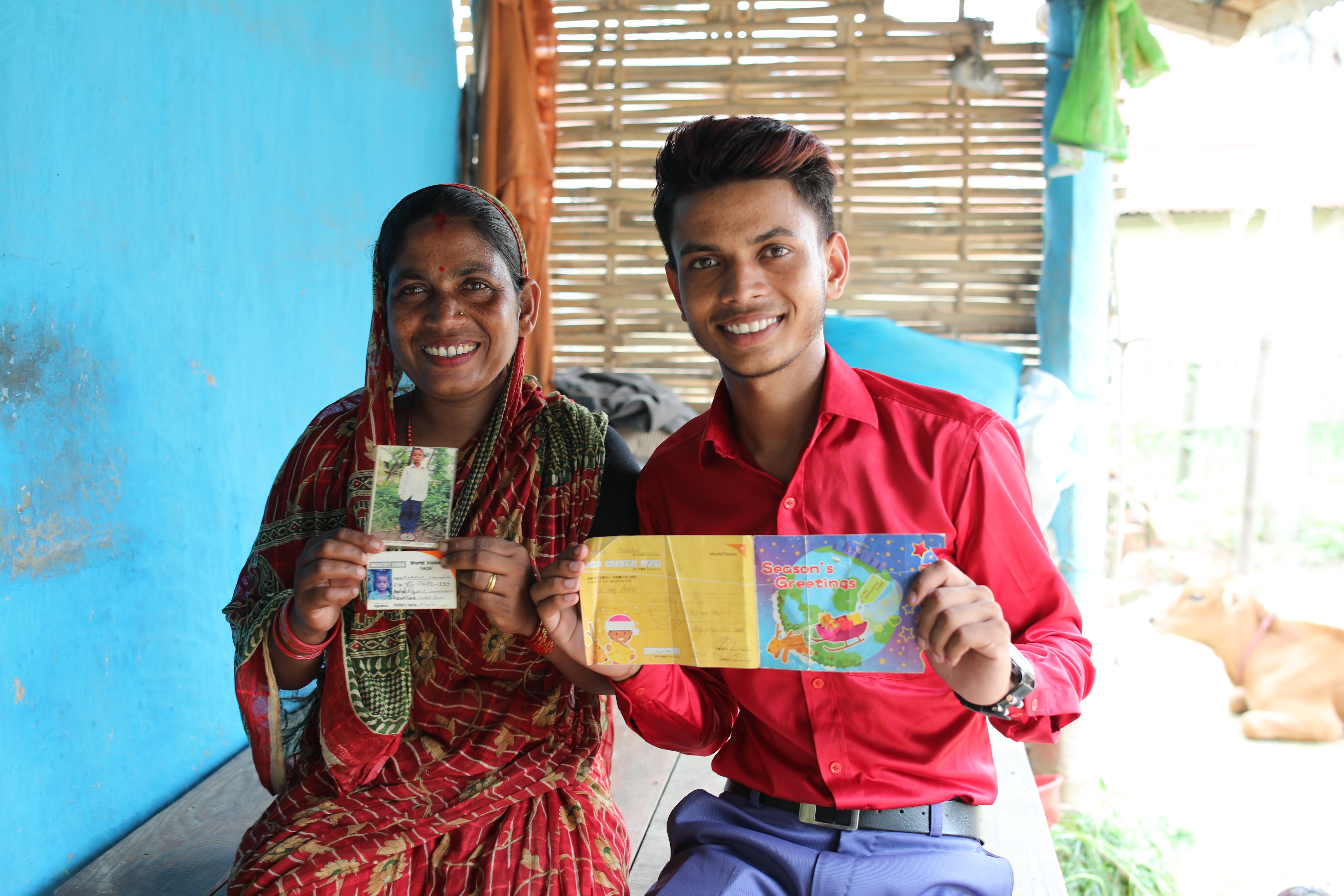 Chandan shows a postcard from his sponsor, while his mother (left) displays sponsorship card and a photo of Chandan