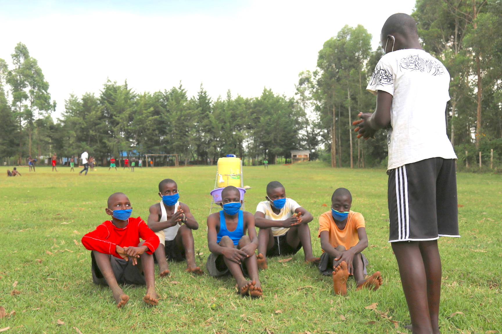 Raphael sensitises his friends on COVID-19 prevention strategies before they begin playing football.©World Vision Photo/Irene Sinoya.