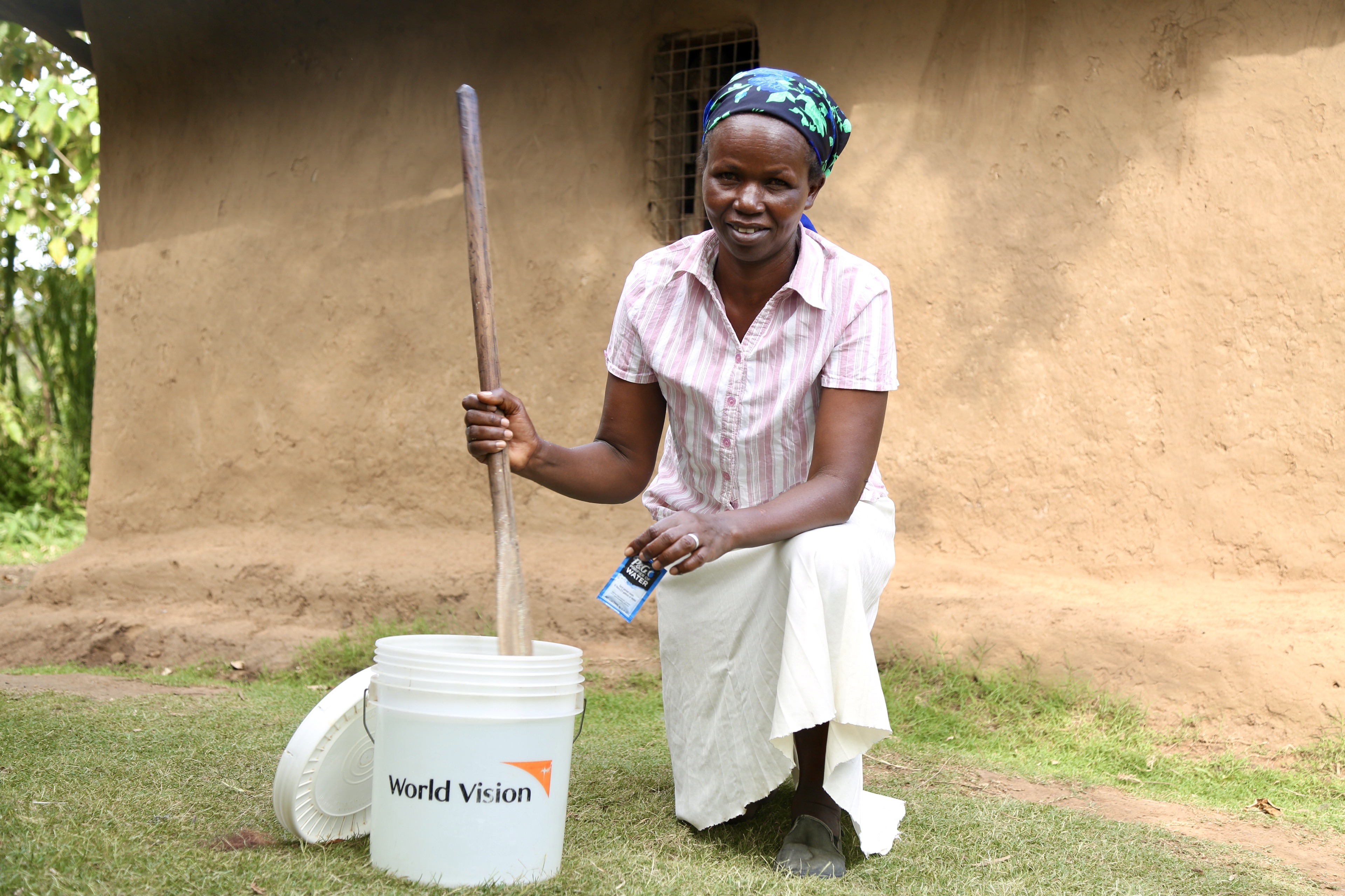 Lily, a resident in Bandaptai, Bomet County poses with an innovative water purification technology provided by P&G and World Vision to purify contaminated water in just 30 minutes. She now gives clean water to her family of 11 children.