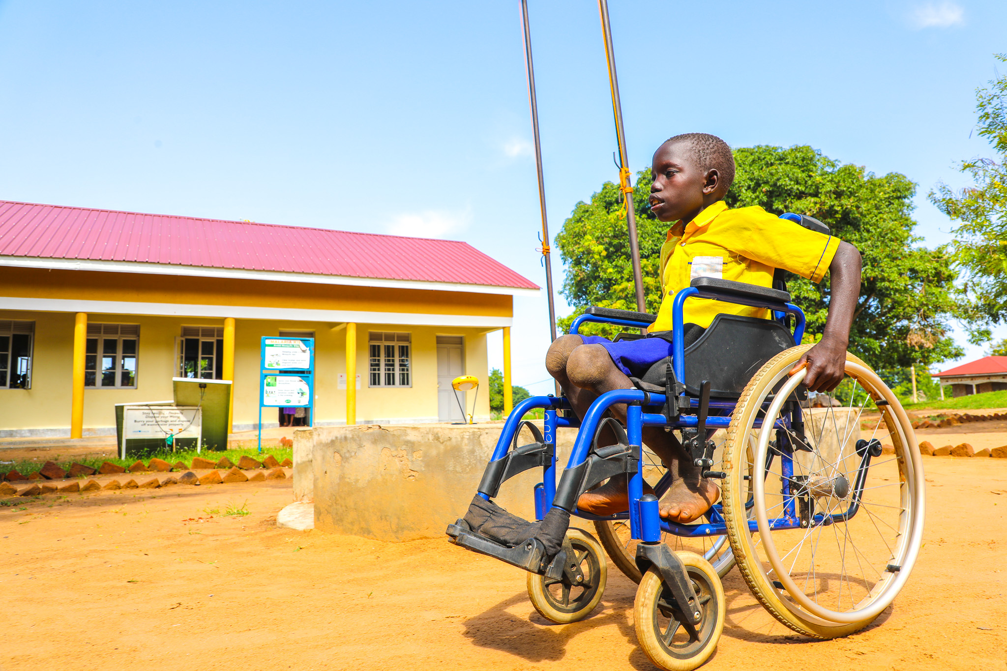 Lematia pushing his wheelchair on the school compound.