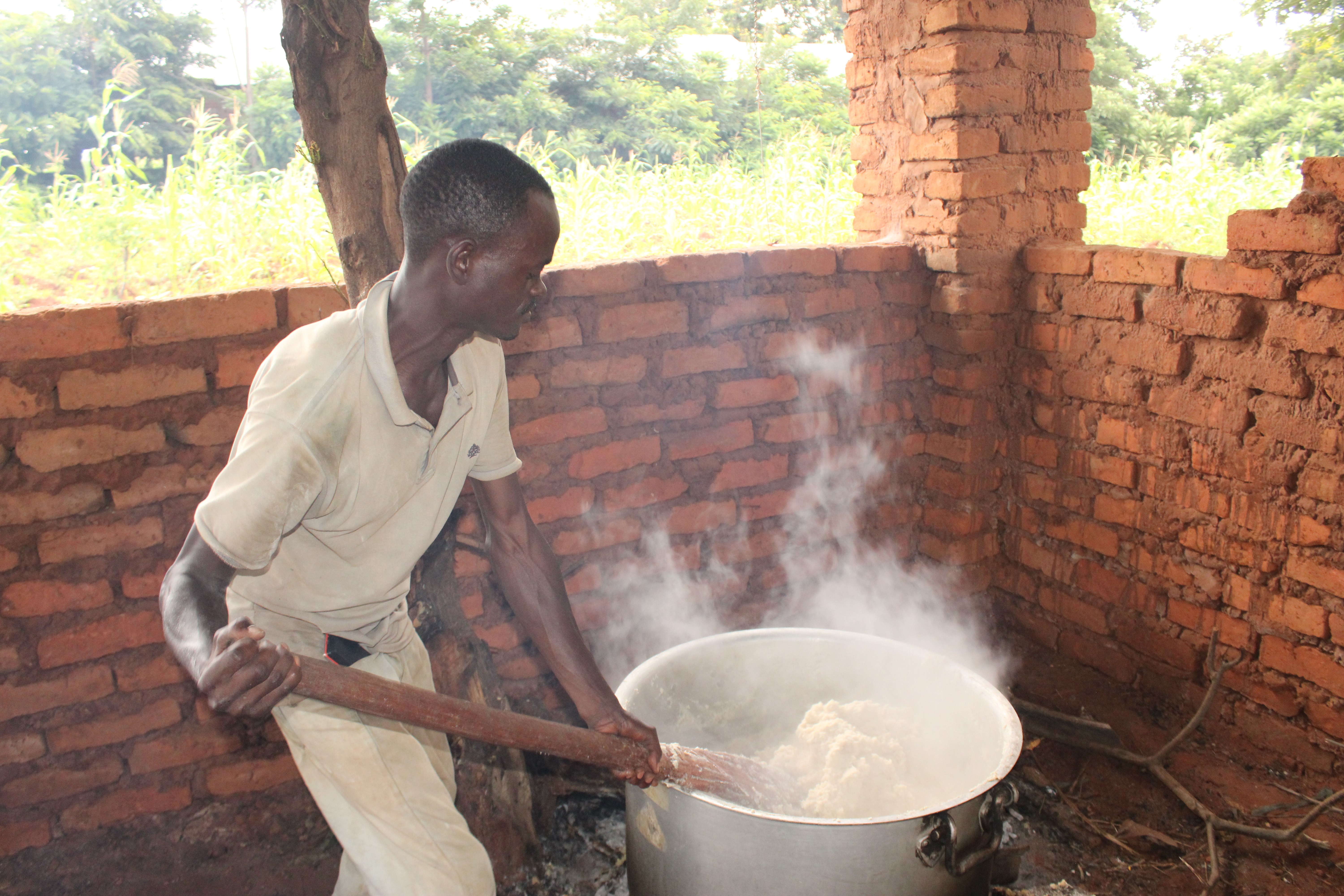 A parent preparing food in a school canteen at a local school in Nyanza-Lac commune