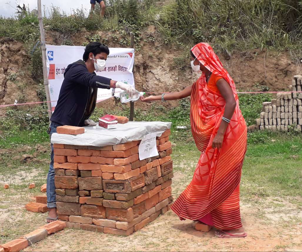 A beneficiary sanitises her hand at the distribution centre