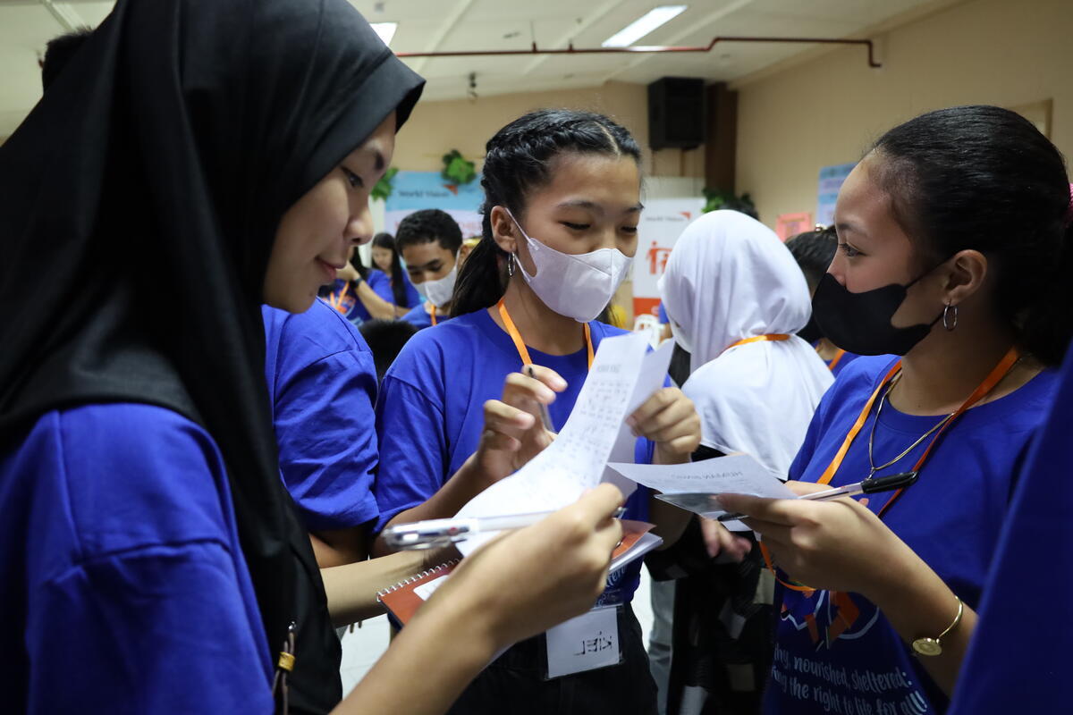 A group of girls share notes during the Children's congress.