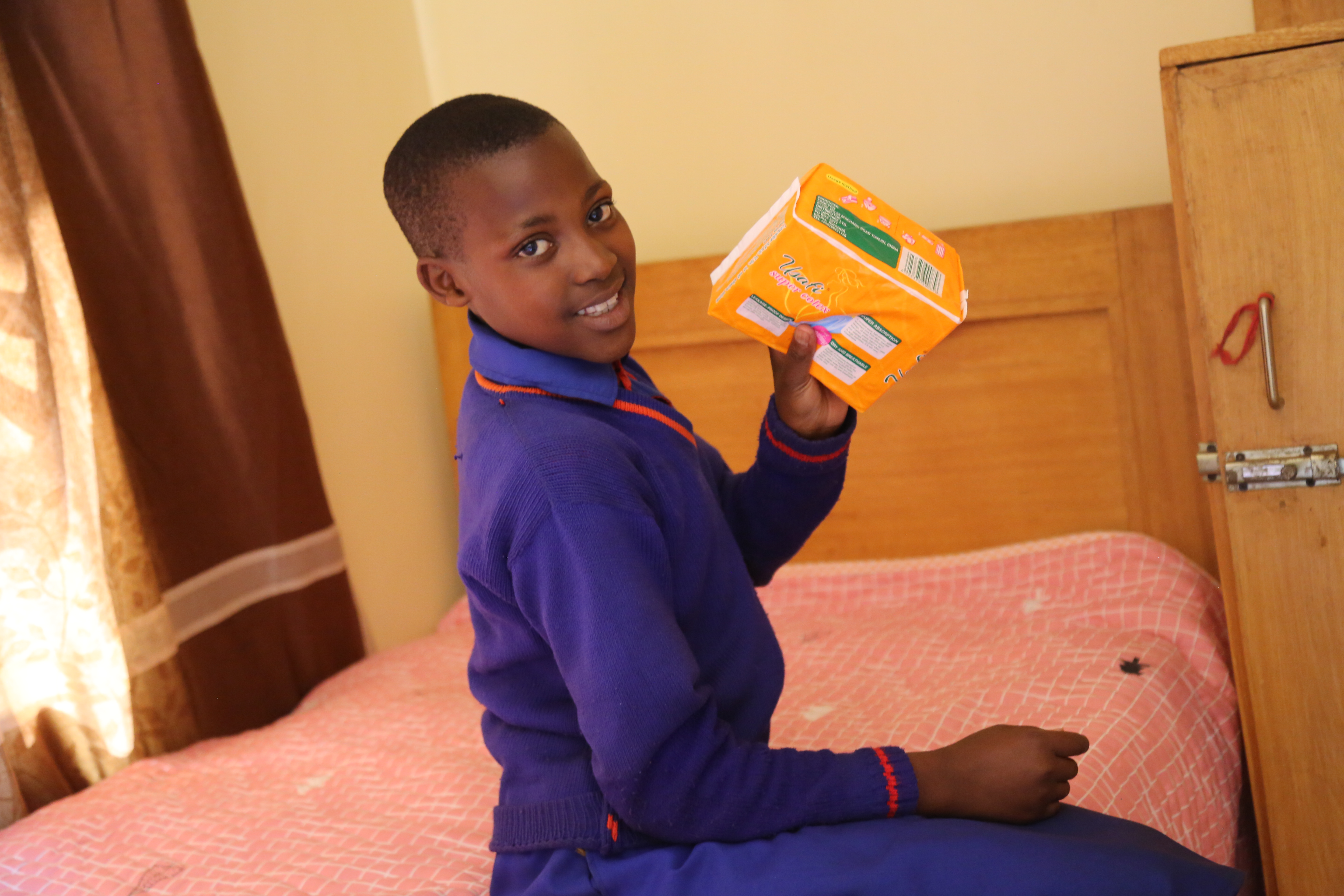 A girl holding her sanitary pads in school