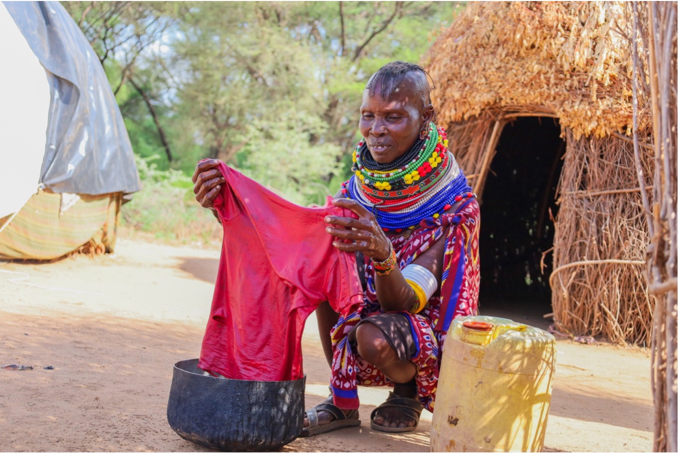 Edome Lokopu, a mother of seven from Nakechurtak village, smiles as she washes her children's clothes effortlessly at a newly installed water source provided by a World Vision water project. The accessible water has significantly improved daily life for her family and community. © World Vision Photo/Felix Pilipili