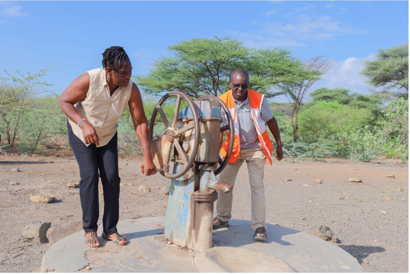 Women struggle to operate a manual water pump, their efforts visibly taxing. The pump, with a small water trough, accommodates only five animals at a time, leading to frequent water spills on the ground. The wet, slippery floor poses a significant risk of accidents. © World Vision Photo/Felix Pilipili.