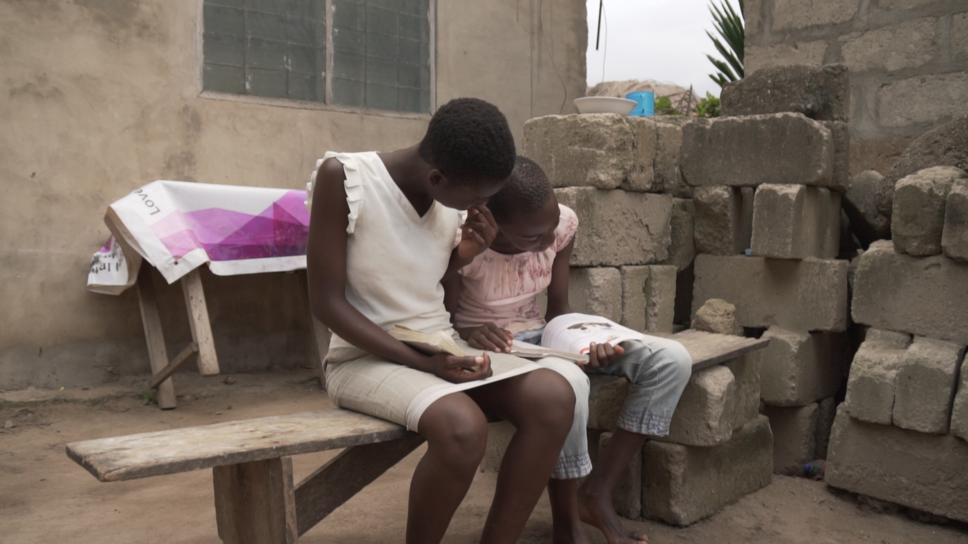 Adjoa studying with her younger sister