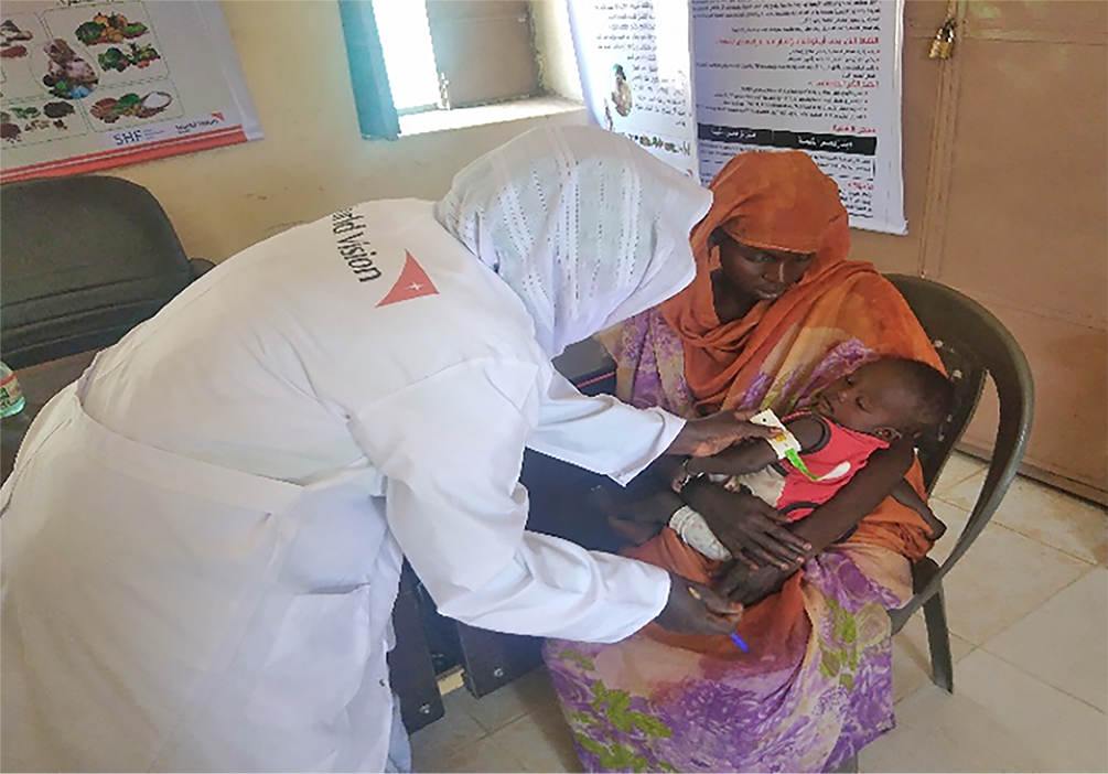 A nutrition specialist screens a child in Sudan for malnutrition 