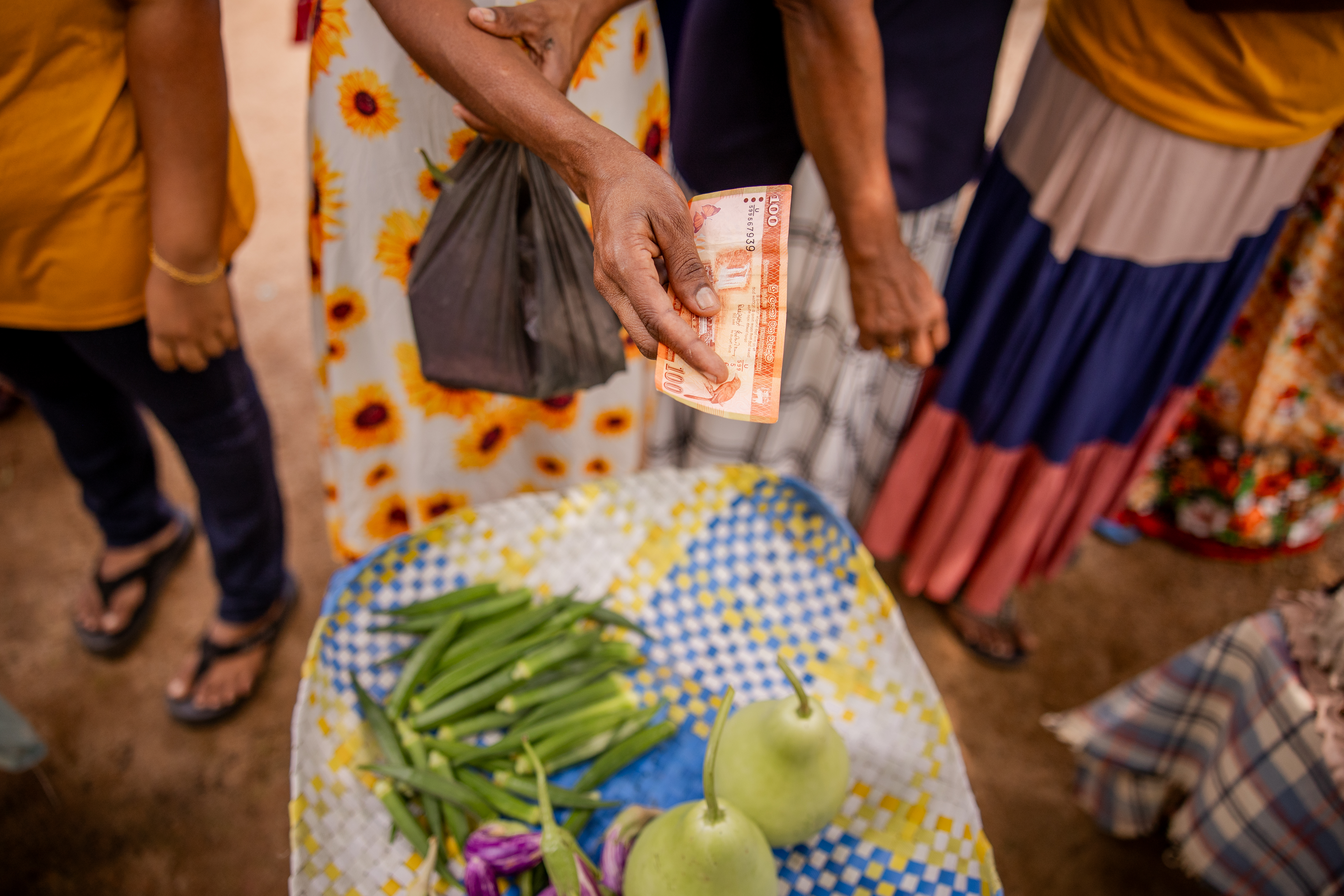 A customer pays for fresh vegetables at a local market.