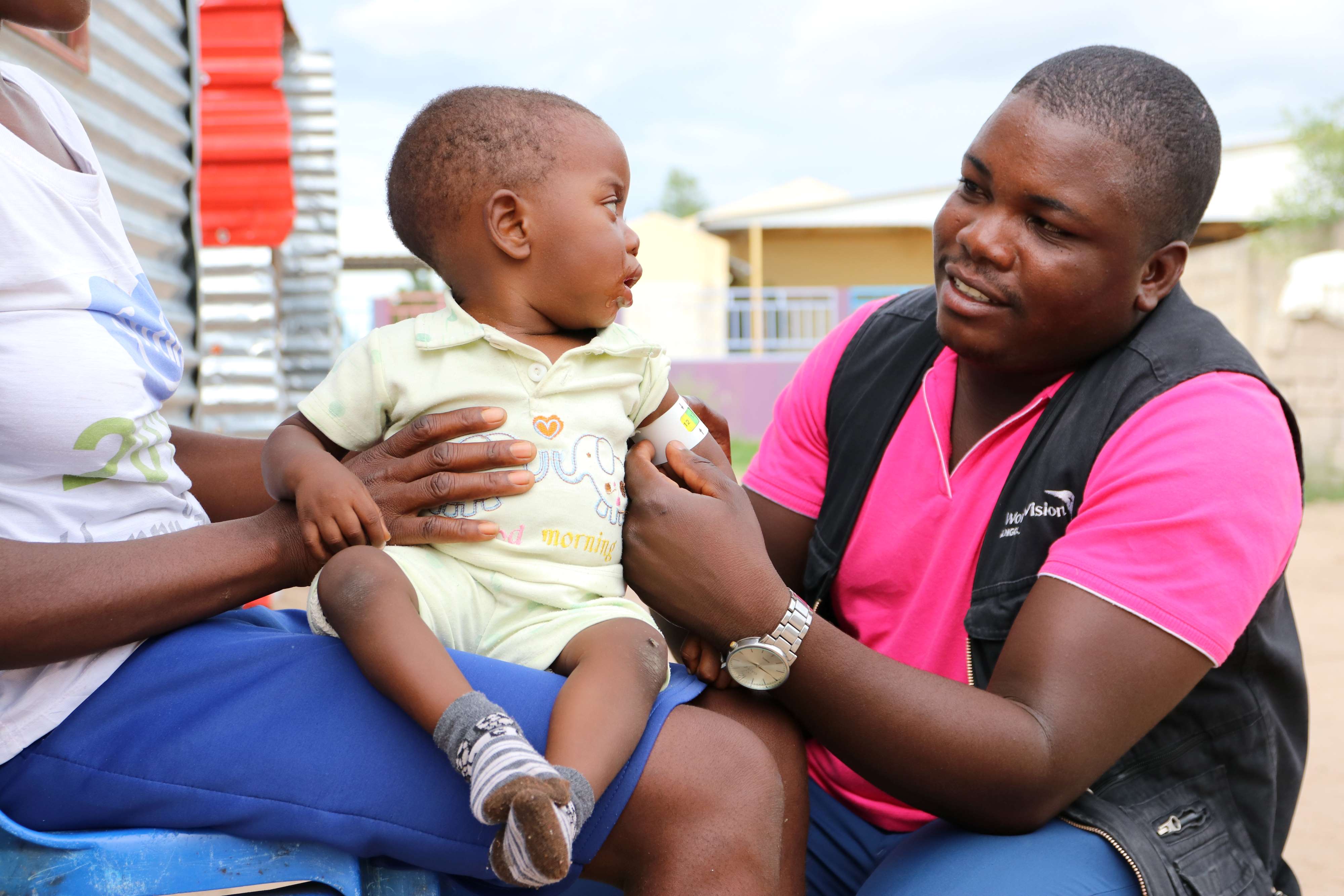 World Vision Community Health Worker Octavio Ndaudadelela measures Beto's mid-upper arm circumference.