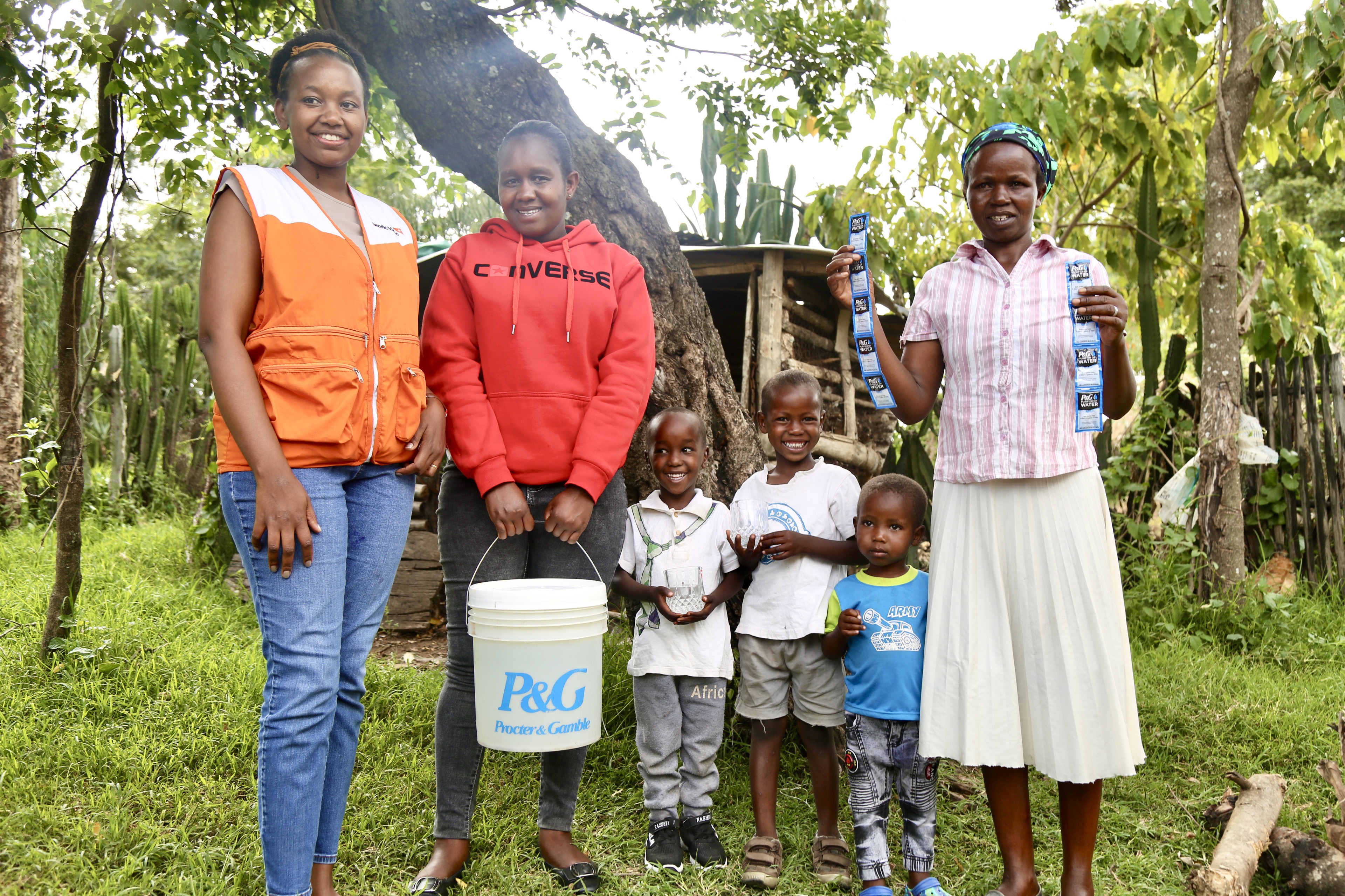 Lily, a mother of 11 in Bandaptai, poses (first left) and some of her children pose with Joan Tonui, World Vision Kenya (first left) and Naomi Cherono, a community health officer in the County of Bomet.