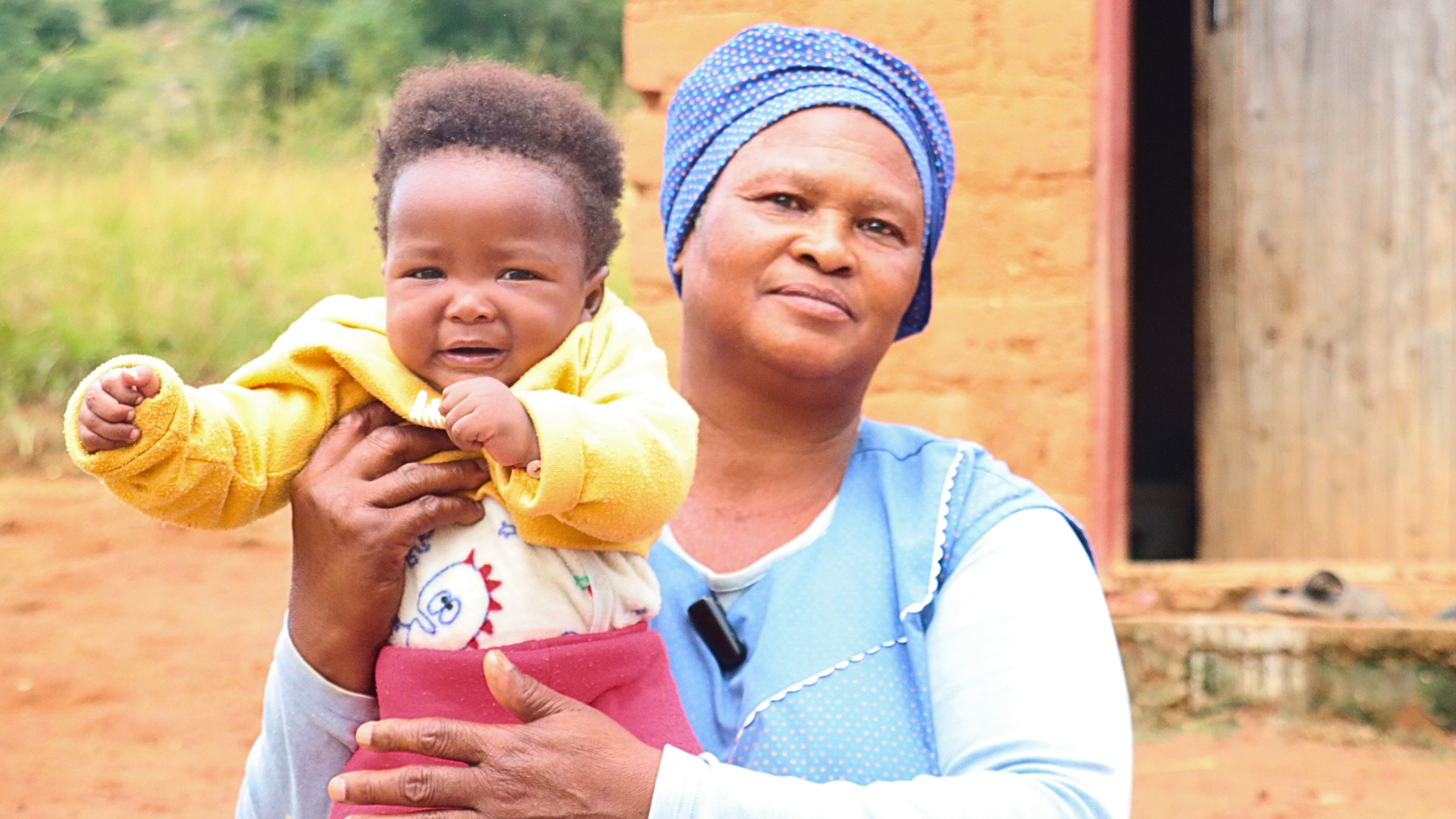 Sonto Hlophe, a Rural Health Motivator holding baby Ayabonga.