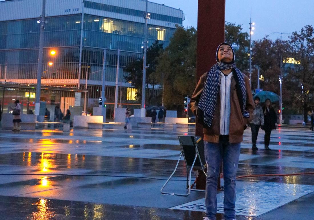 Carlos stands in the rain smiling