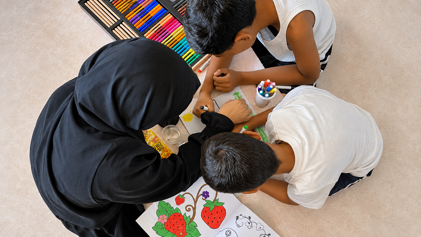 Esraa draws and colours with her sons—one of the small but meaningful ways she is becoming more present in their daily lives after receiving psychosocial support.