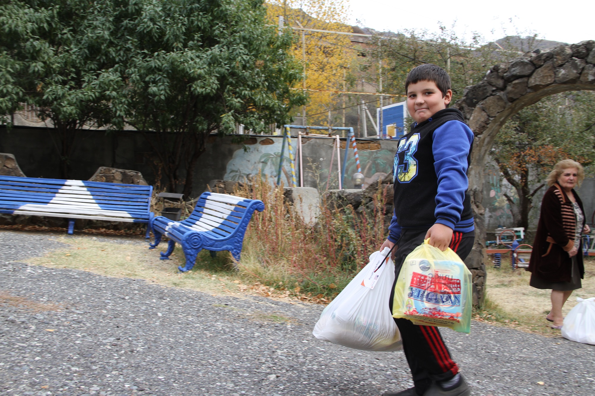 Child carrying bags of aid  in Armenia 