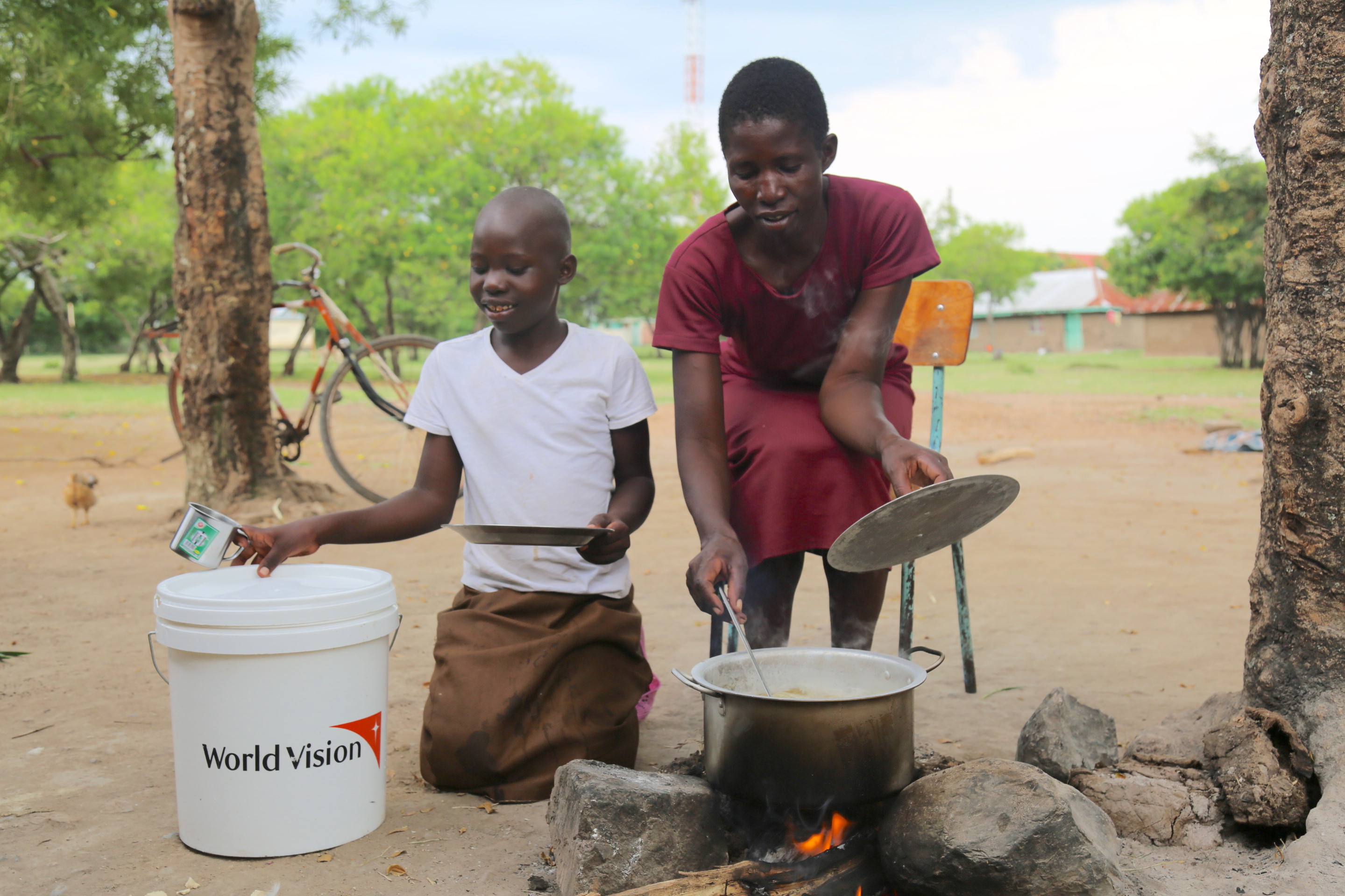 Elseba and her daughter Mitchell preparing food at the camp using the cooking utensils that they received from World Vision. ©World Vision Photo/Irene Sinoya.