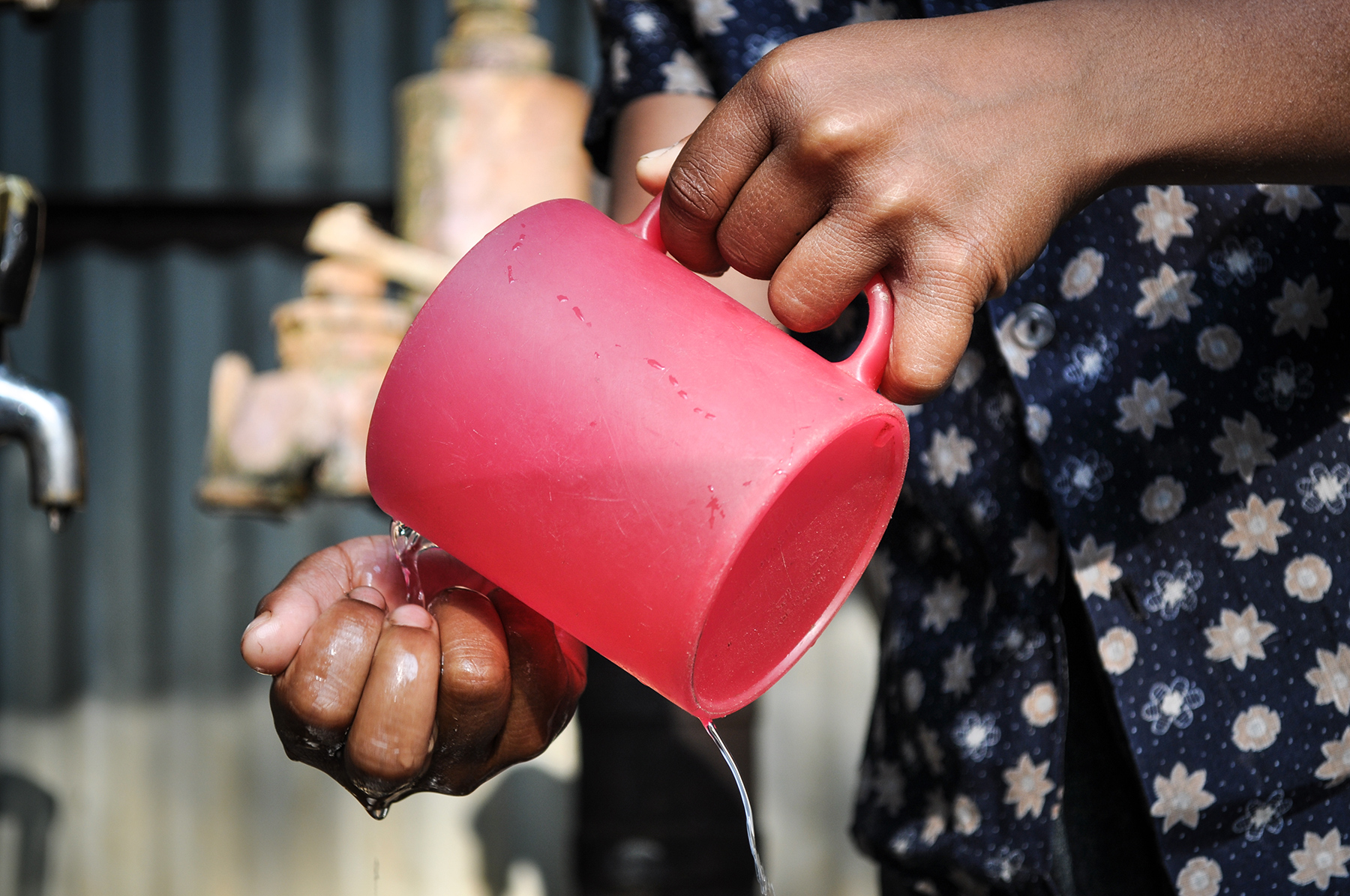 A woman pours water from a cup in Bangladesh