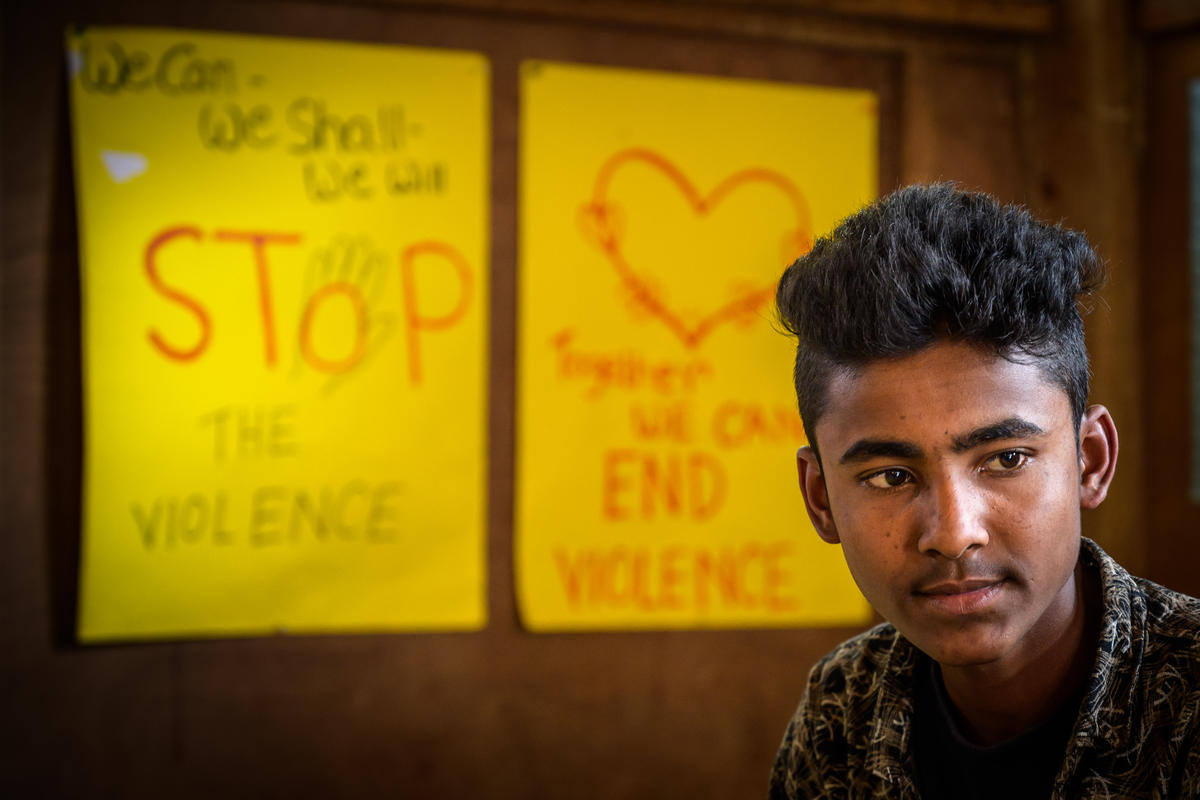 Youth standing in front of a poster