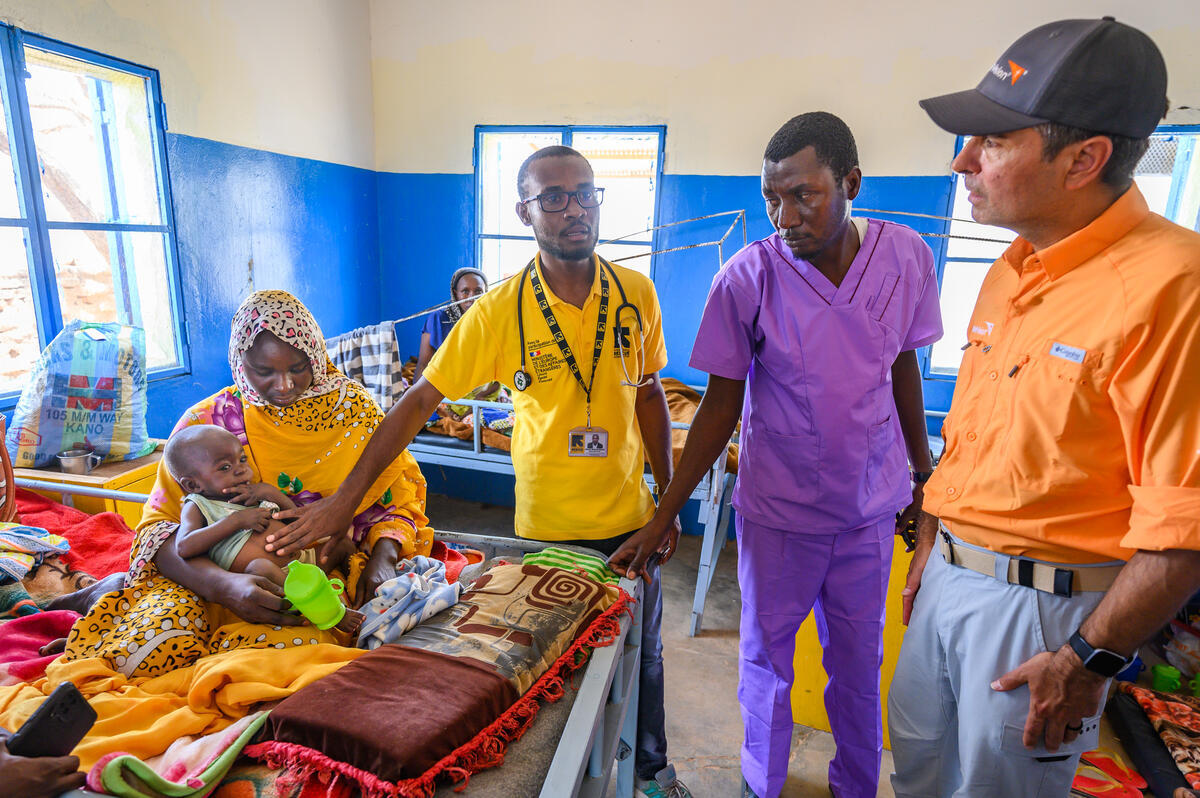 Dr. Albachir Mahamat Albachir (in yellow shirt), the head of the nutrition and rehabilitation center run by the International Rescue Committee in Farchana, Chad, introduces Edgar Sandoval Sr, WVUS President and CEO
