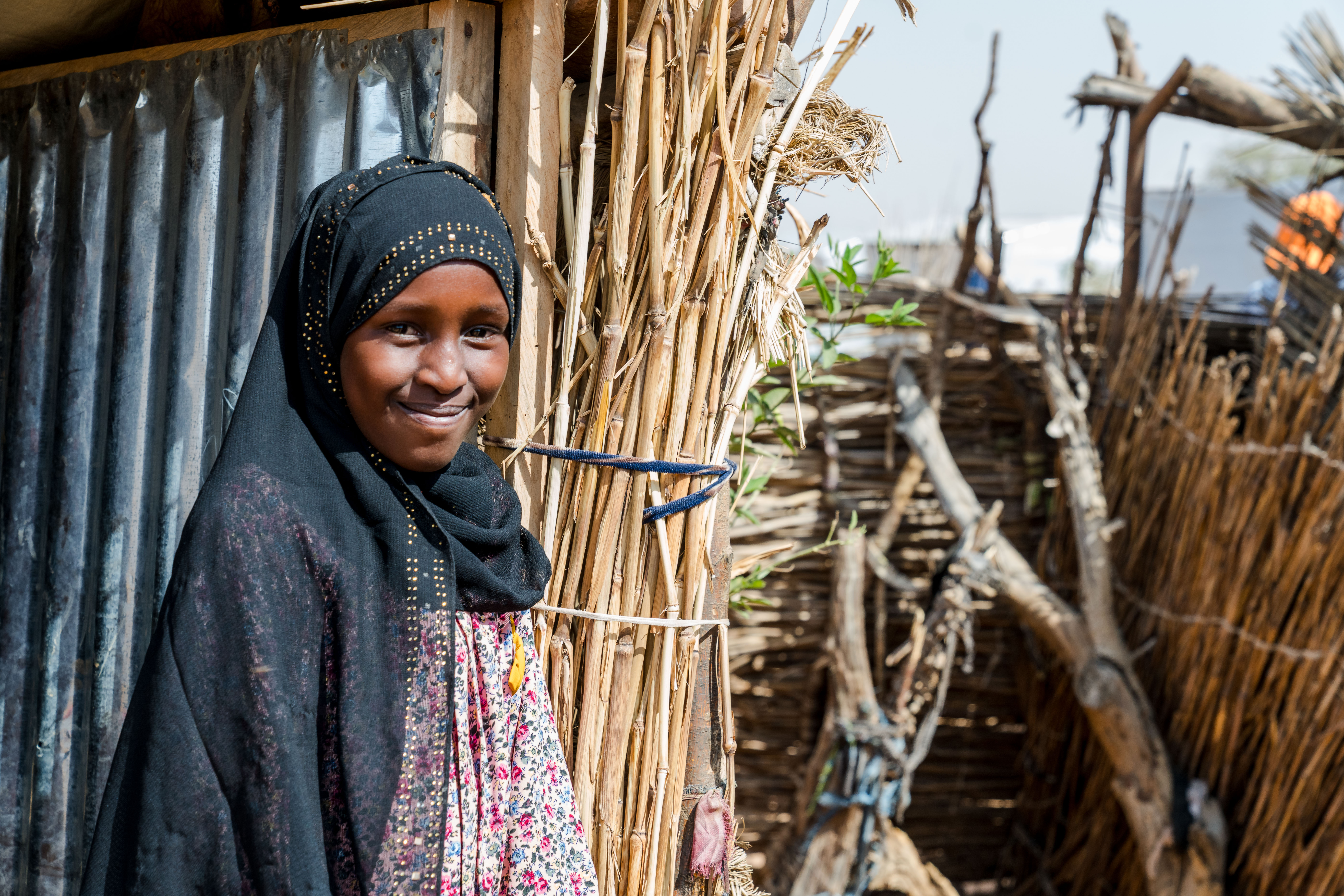 Saba, 14, stands outside her family’s shelter in Farchana Refugee Camp.