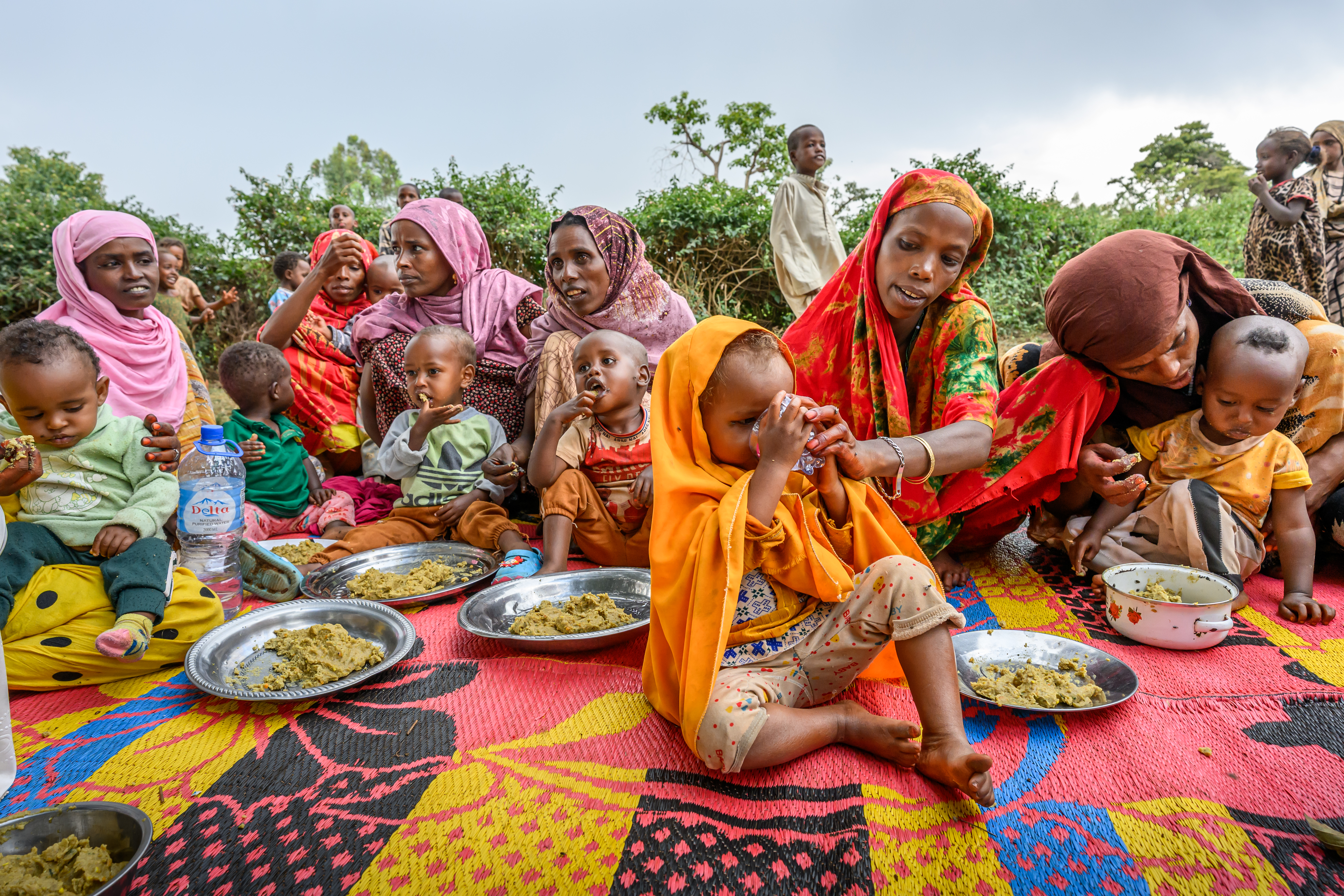 Women feed their children nutritious porridge at a World Vision Nurturing Care Group meeting in Milino Village, Ethiopia.