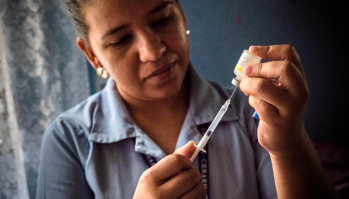A nurse prepares an injection