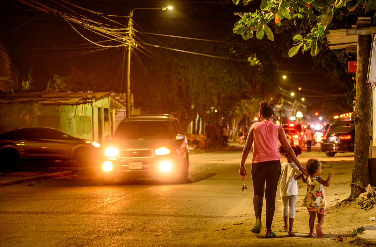 parent and child walking next to a road