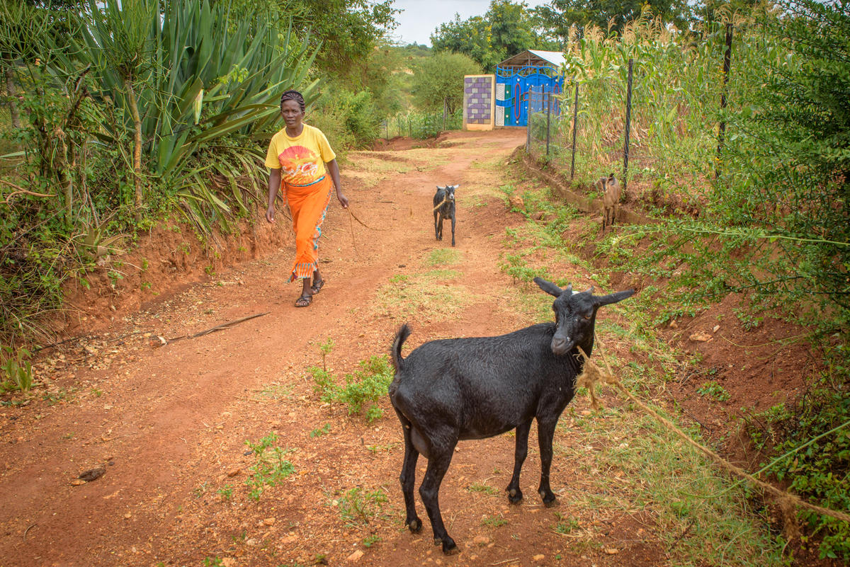 Janet with the goats her family was given which now help the family provide nutritious food