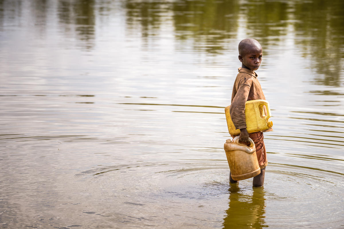 a child getting water from a river