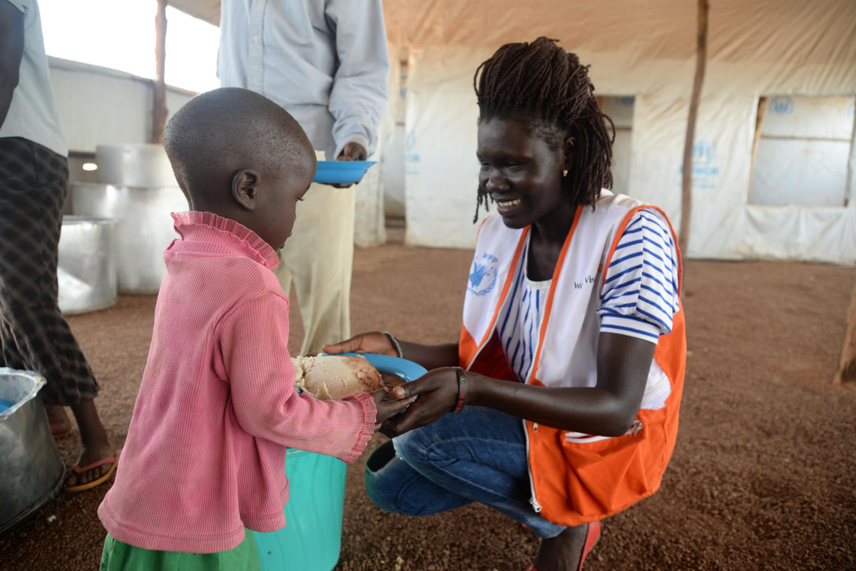 World Vision staff member Rahima serves a hot meal to South Sudan refugees.