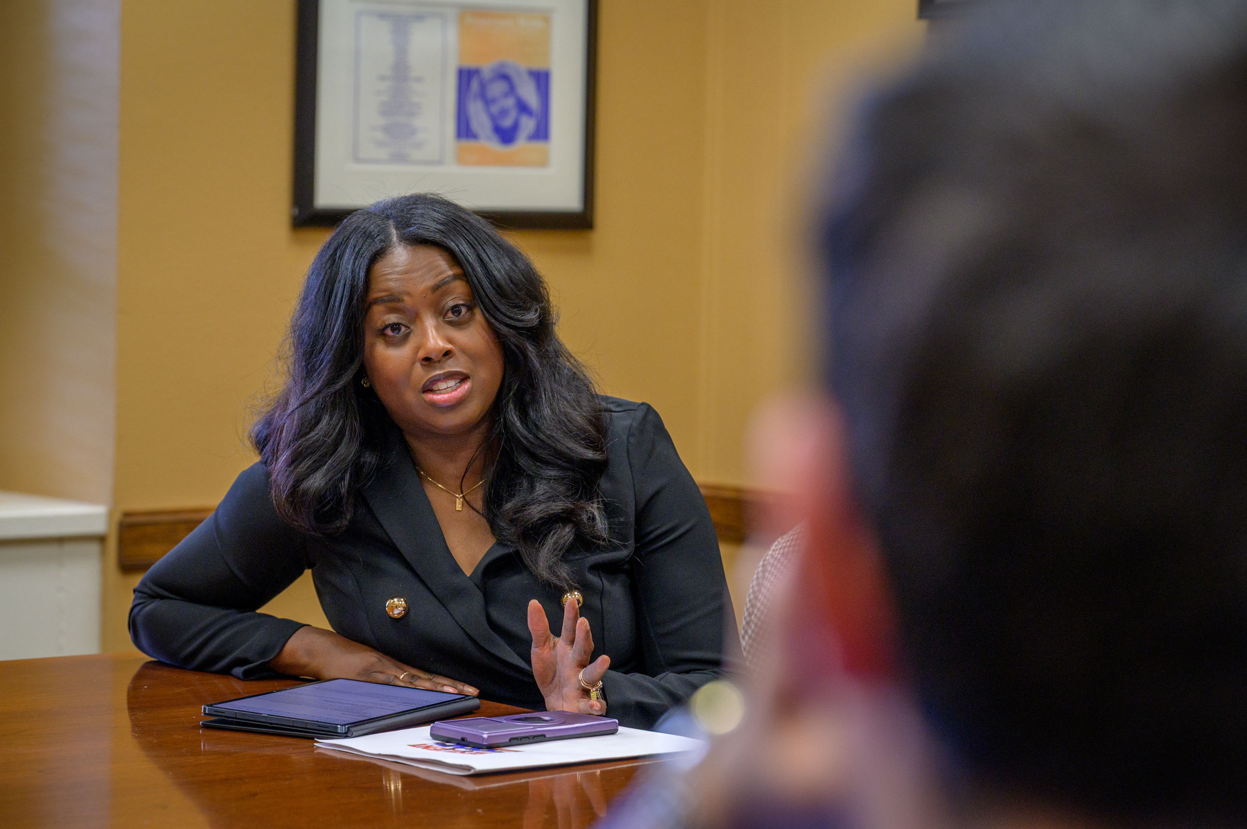 A woman sits a table talking.