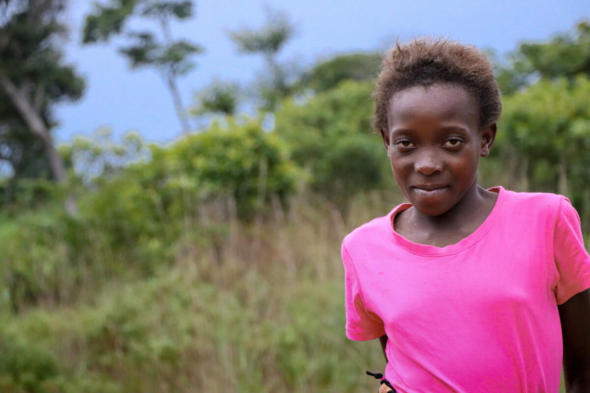 girl stands outside wearing a pink shirt