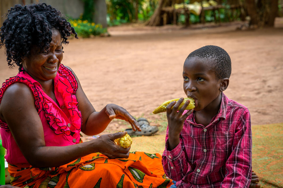 A mother feeding her child corn