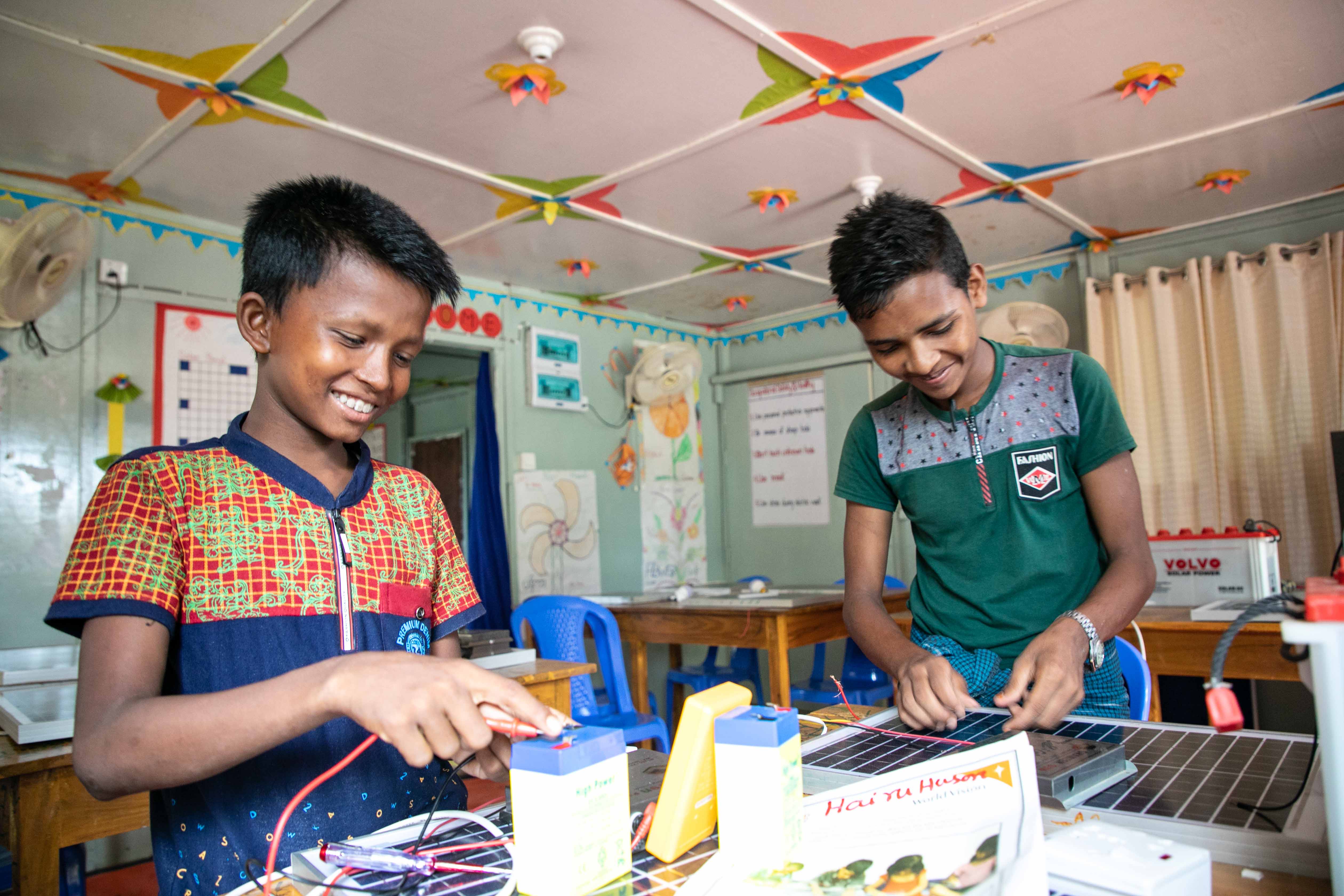 EDUCATION:  Adolescent boys enjoy learning solar panel and light repair at World Vision’s multi-purpose centre.