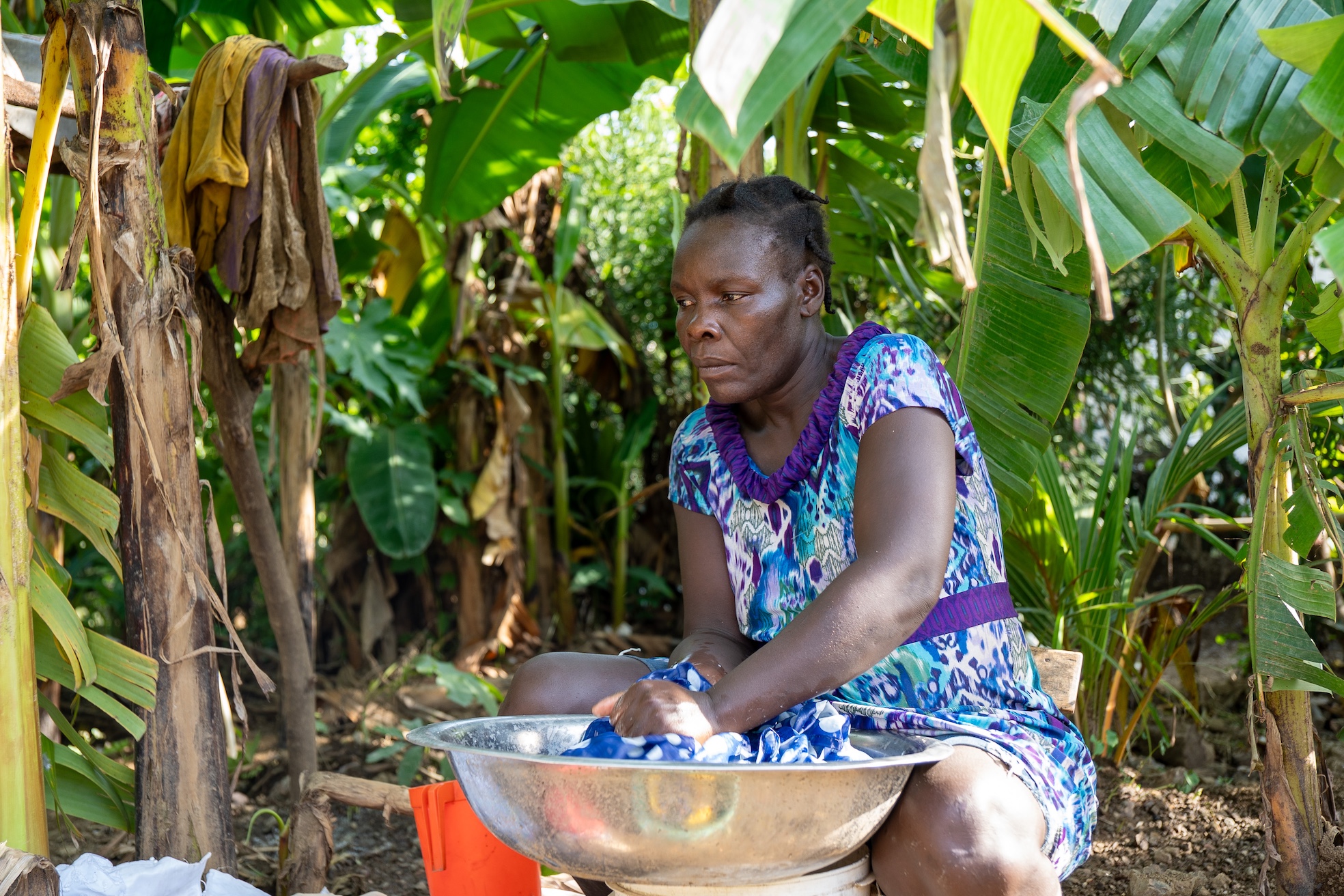 Enize tries to salvage some clothes from the mud