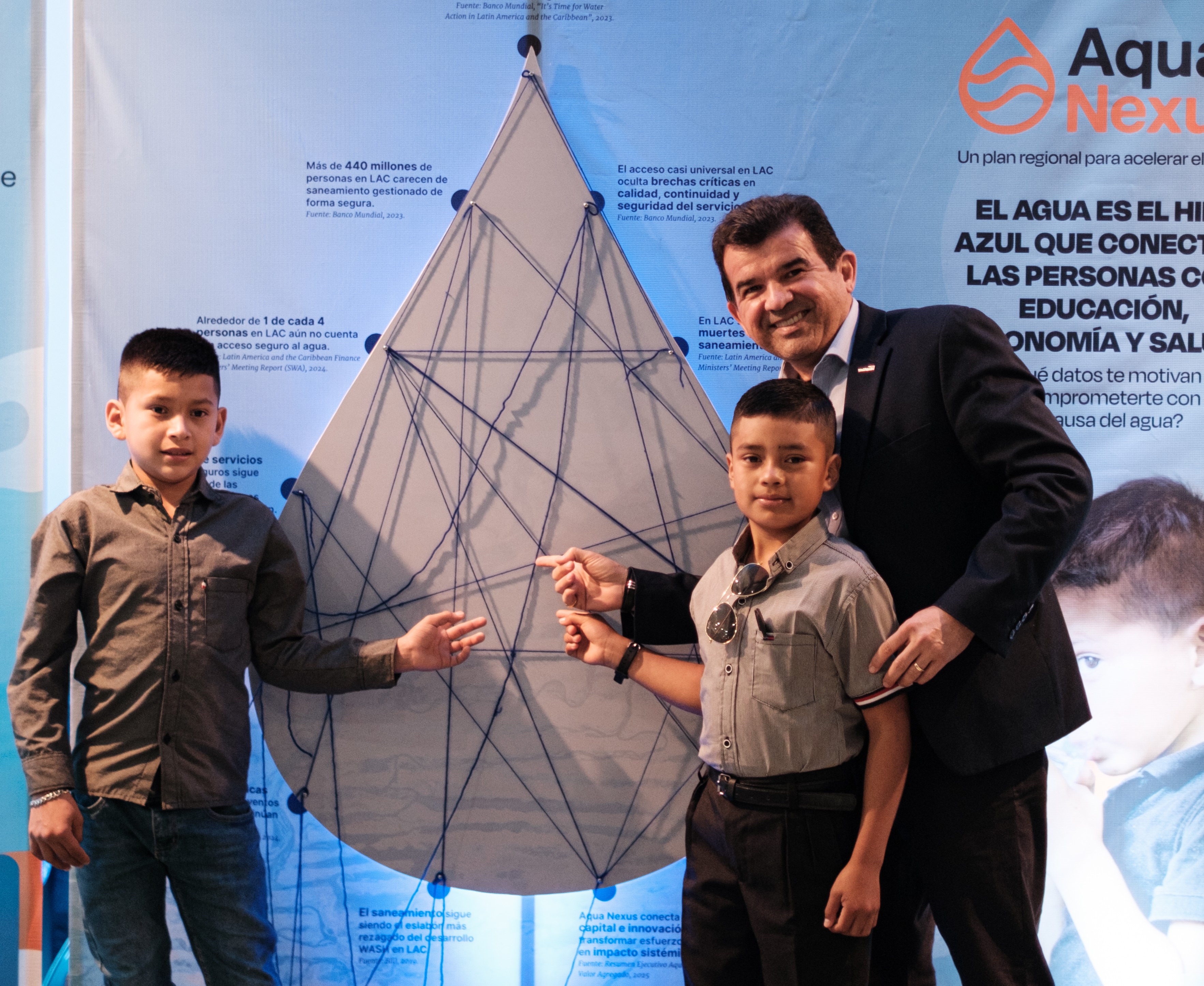 Joao Diniz, Regional Leader for Latin America and the Caribbean at World Vision, stands with children during the  AQUA Nexus presentation.