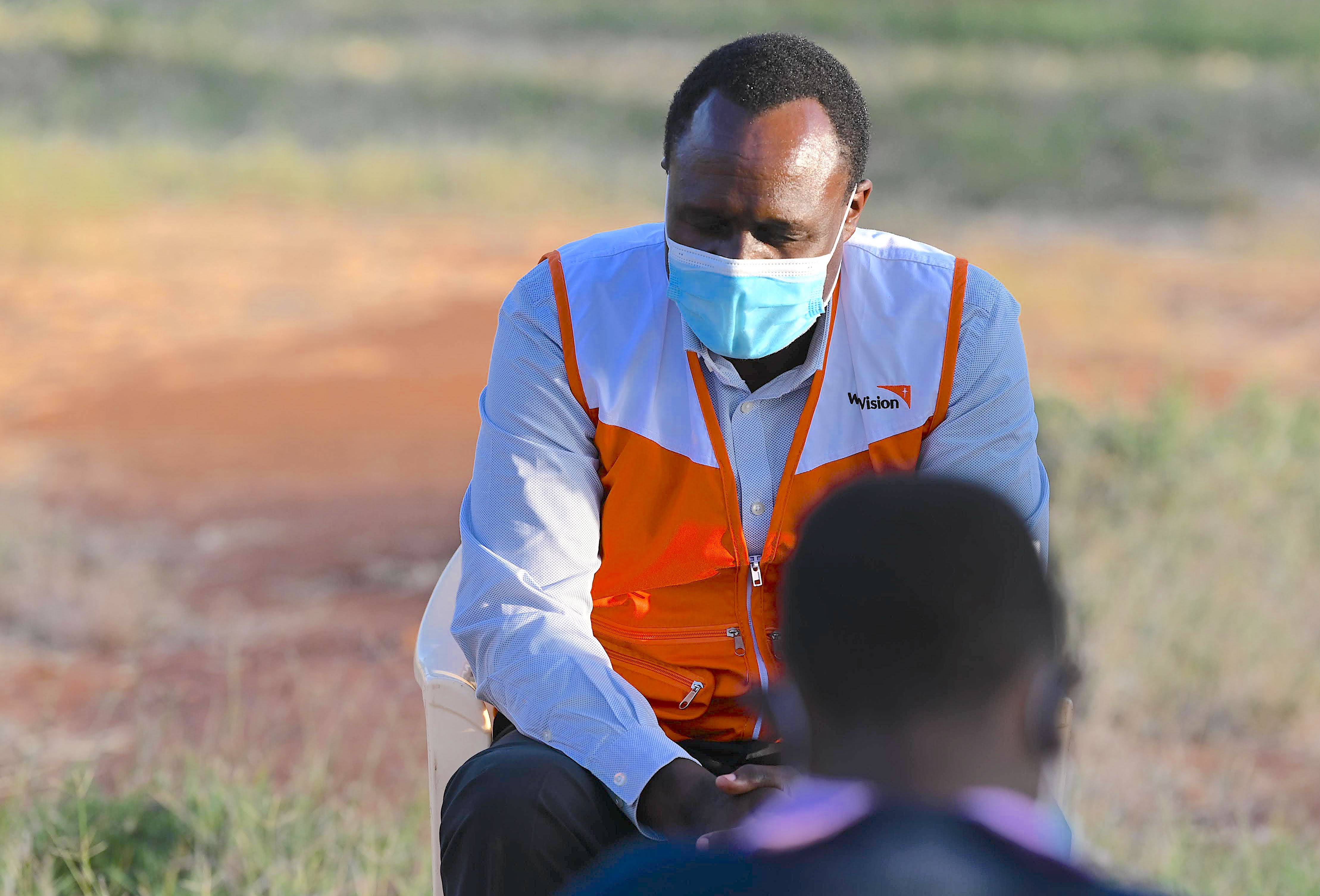 Paul Lilian, the Board Chair of World Vision prays with Esther during a visit to the rescue centre. ©World Vision Photo/Martin Muluka.