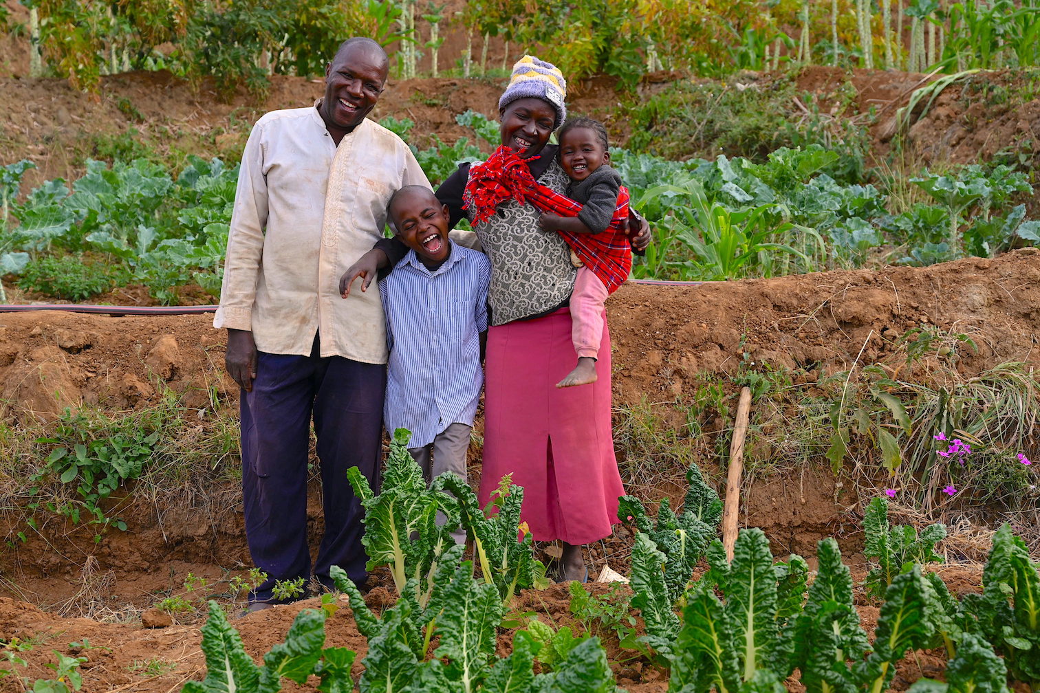 Joshua (centre) is happy that he no has sufficient food to eat at home. His parents are also able to cater for his basics needs, thanks to the proceeds from their farm. ©World Vision Photo/Sarah Ooko.