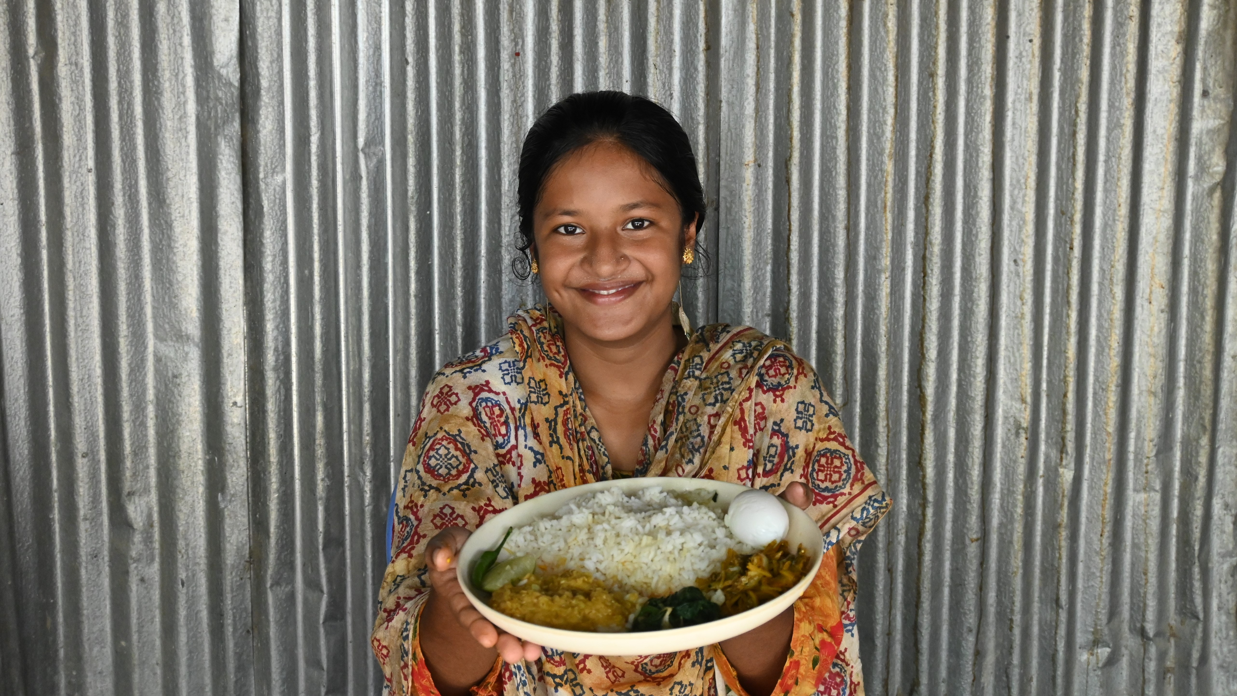 To the best of her abilities, she maintains balanced diets required during adolescence e.g. eating eggs, fish, and lentils that provide protein, vegetables for required vitamins, and rice for energy to keep herself active.  She also eats seasonal fruits like guava, banana, and other available fruits for complementary vitamins and minerals to stay healthy.  