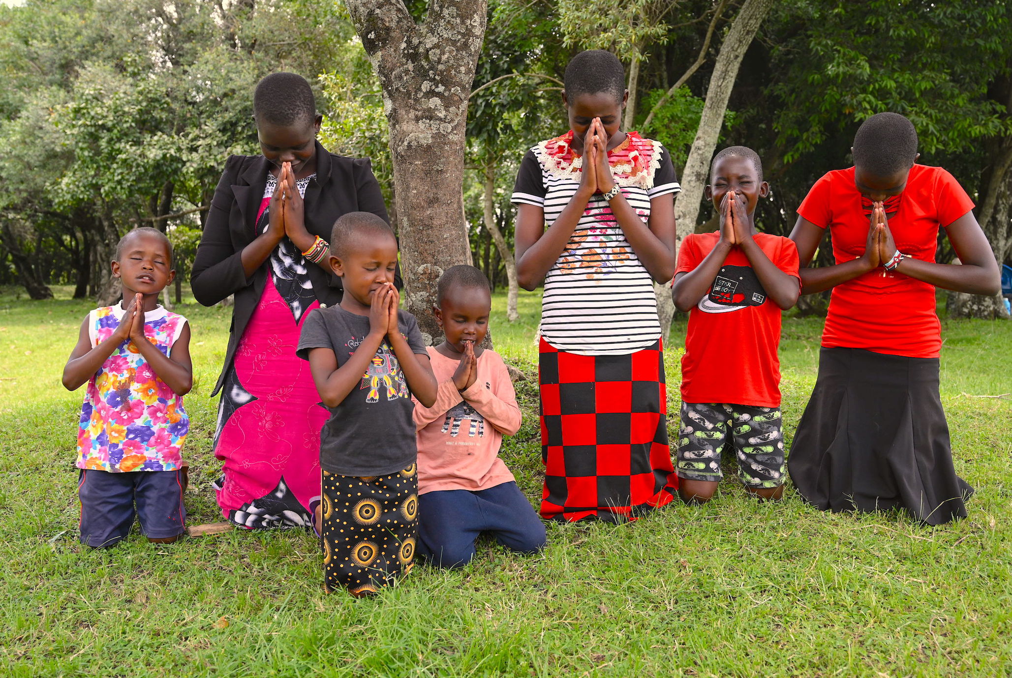 Leah and other children in her community praying to God to protect them from harm and enable the community to end all forms of violence against children.