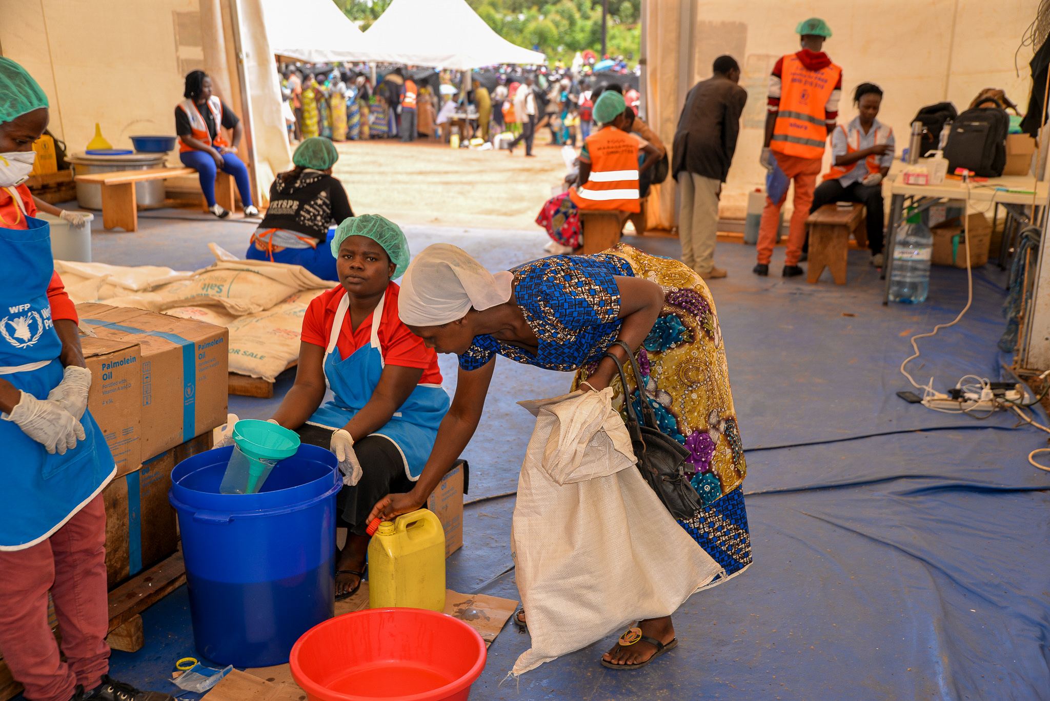 Butoto  (Leaning-with a white bag) receiving her food