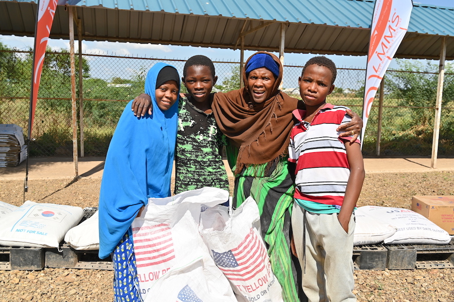 Hadija (holding a scoop of rice) with her three children - Subira aged 16, Hassan aged 14 and Hussein aged 13. They are grateful for the sustainable food supply that they receive through the support of World Vision and WFP.