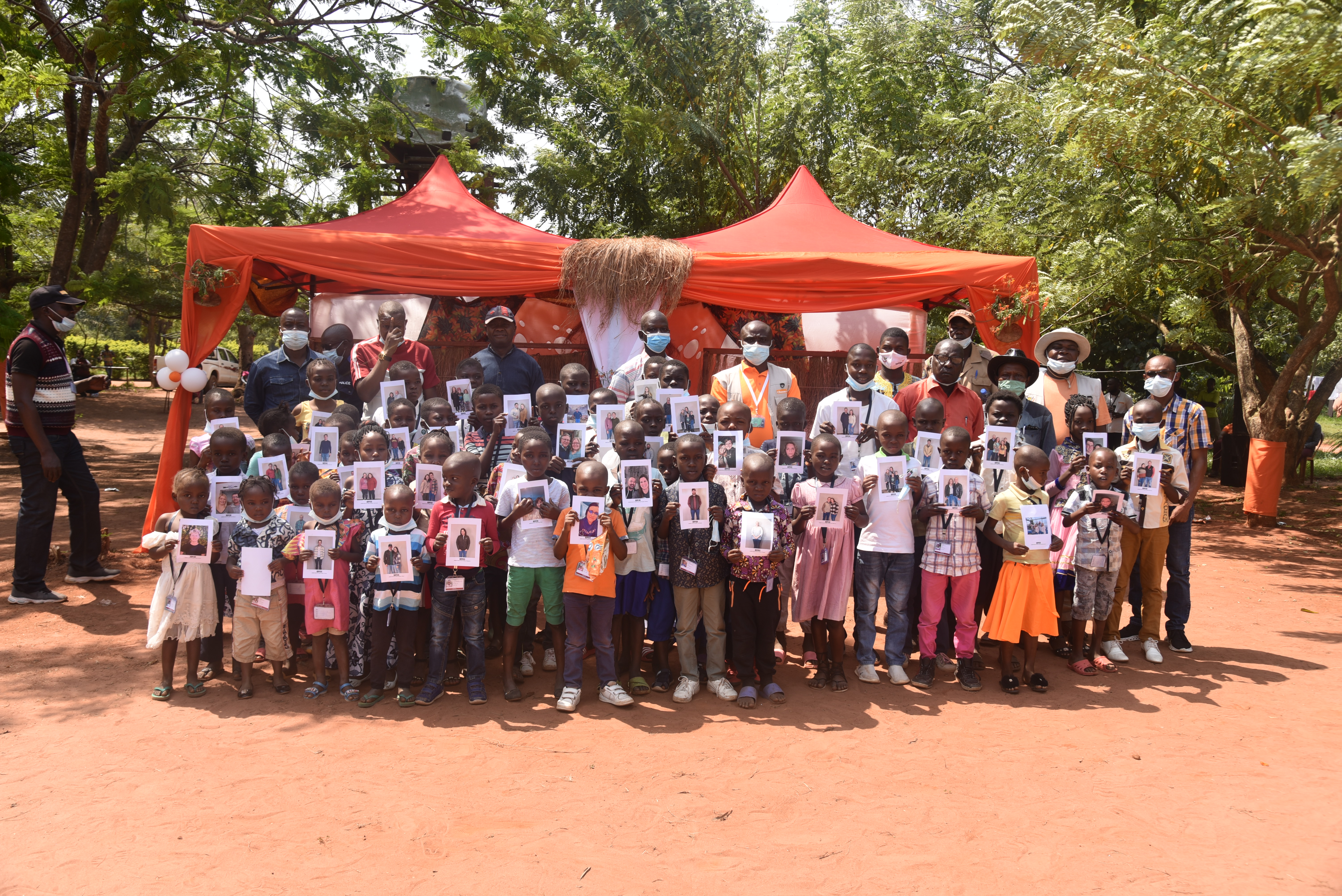 Des enfants exposant les photos de leurs parrains